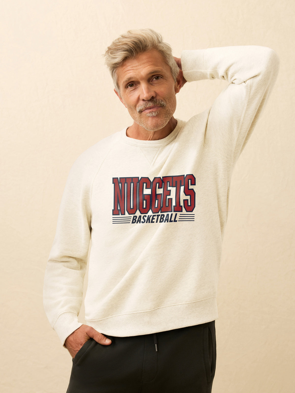 A man wearing a white Denver Nuggets crewneck, image 1 of 2
