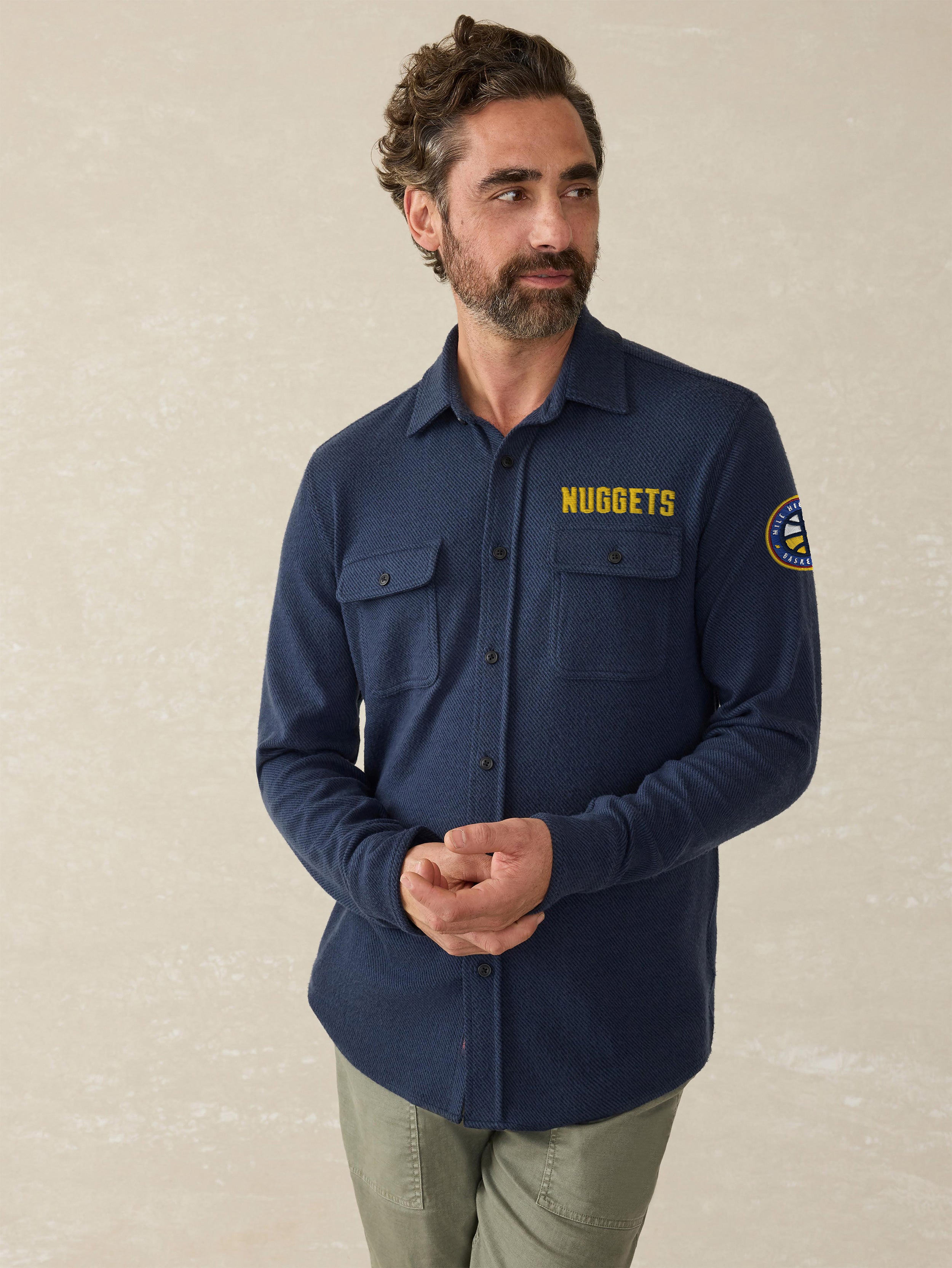 A man wearing a blue Denver Nuggets button up shirt