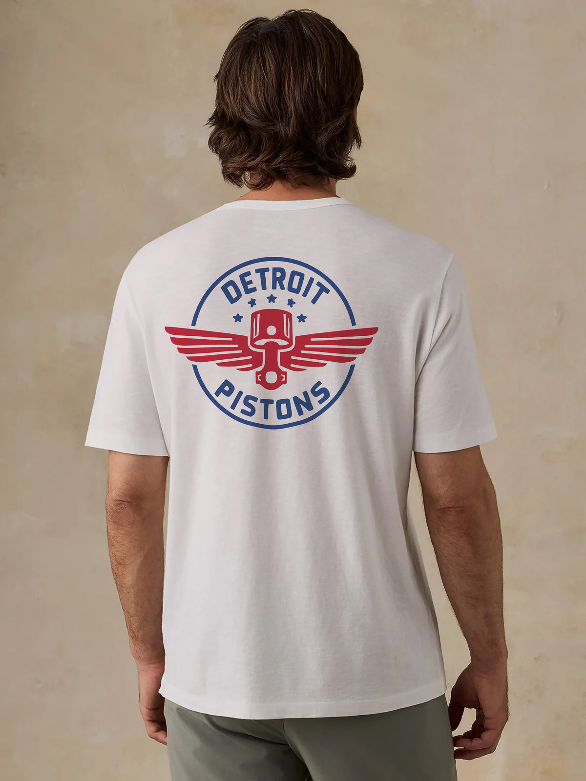 A man viewed from the back wearing a white Detroit Pistons tee, image 2 of 4