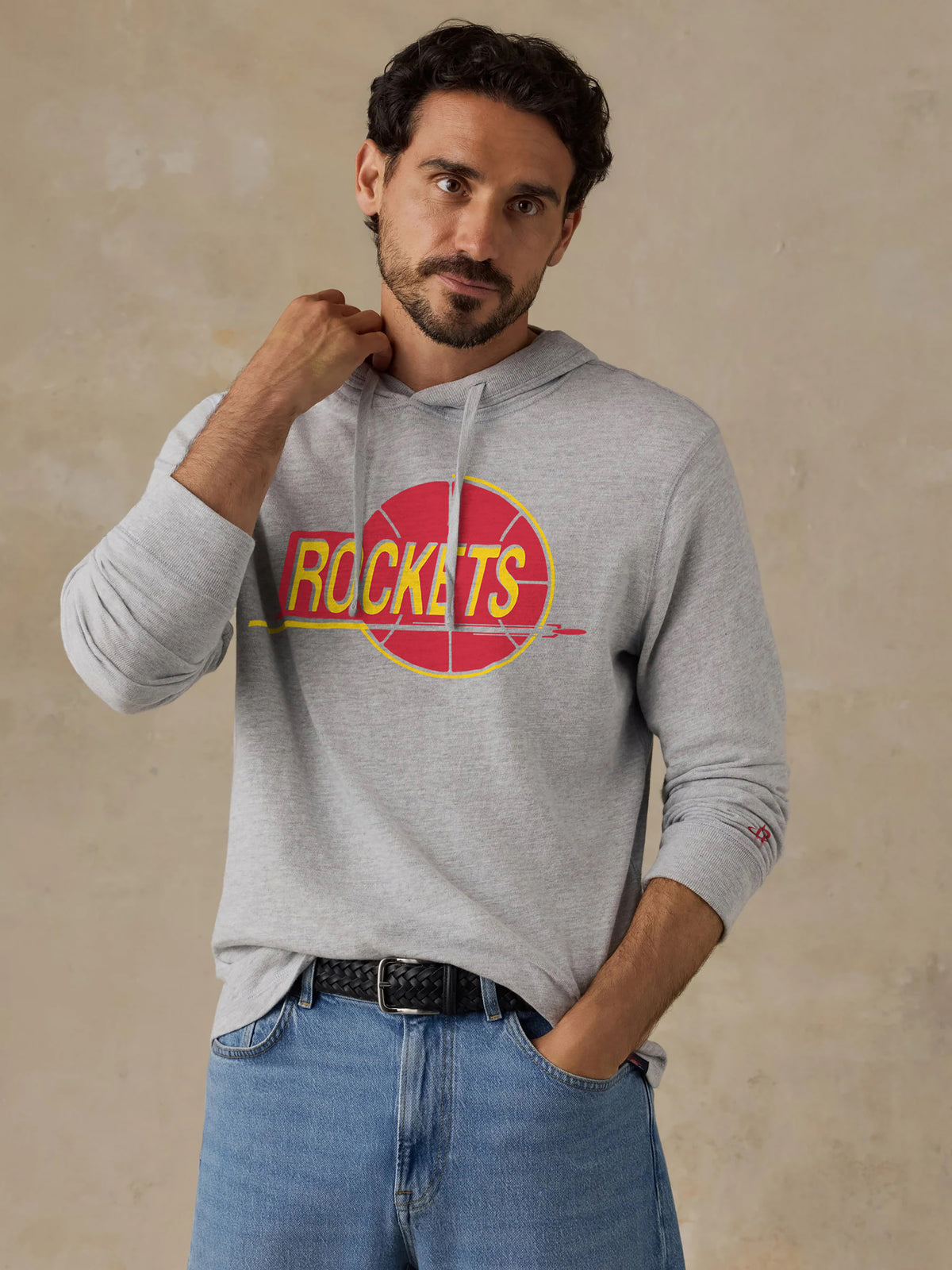 A man wearing a grey Houston Rockets hoodie, image 1 of 2