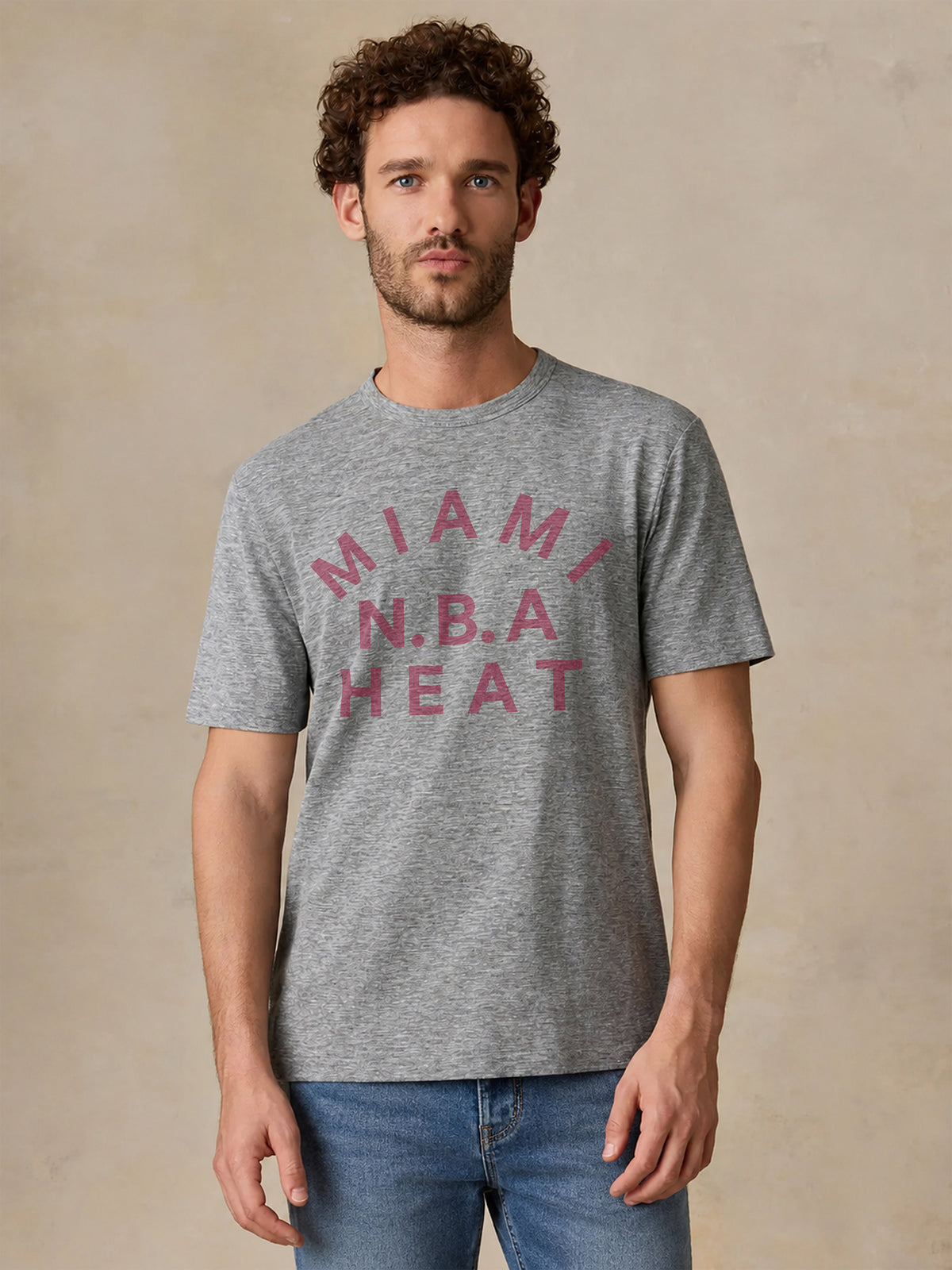 A man wearing a grey Miami Heat tee, image 1 of 2