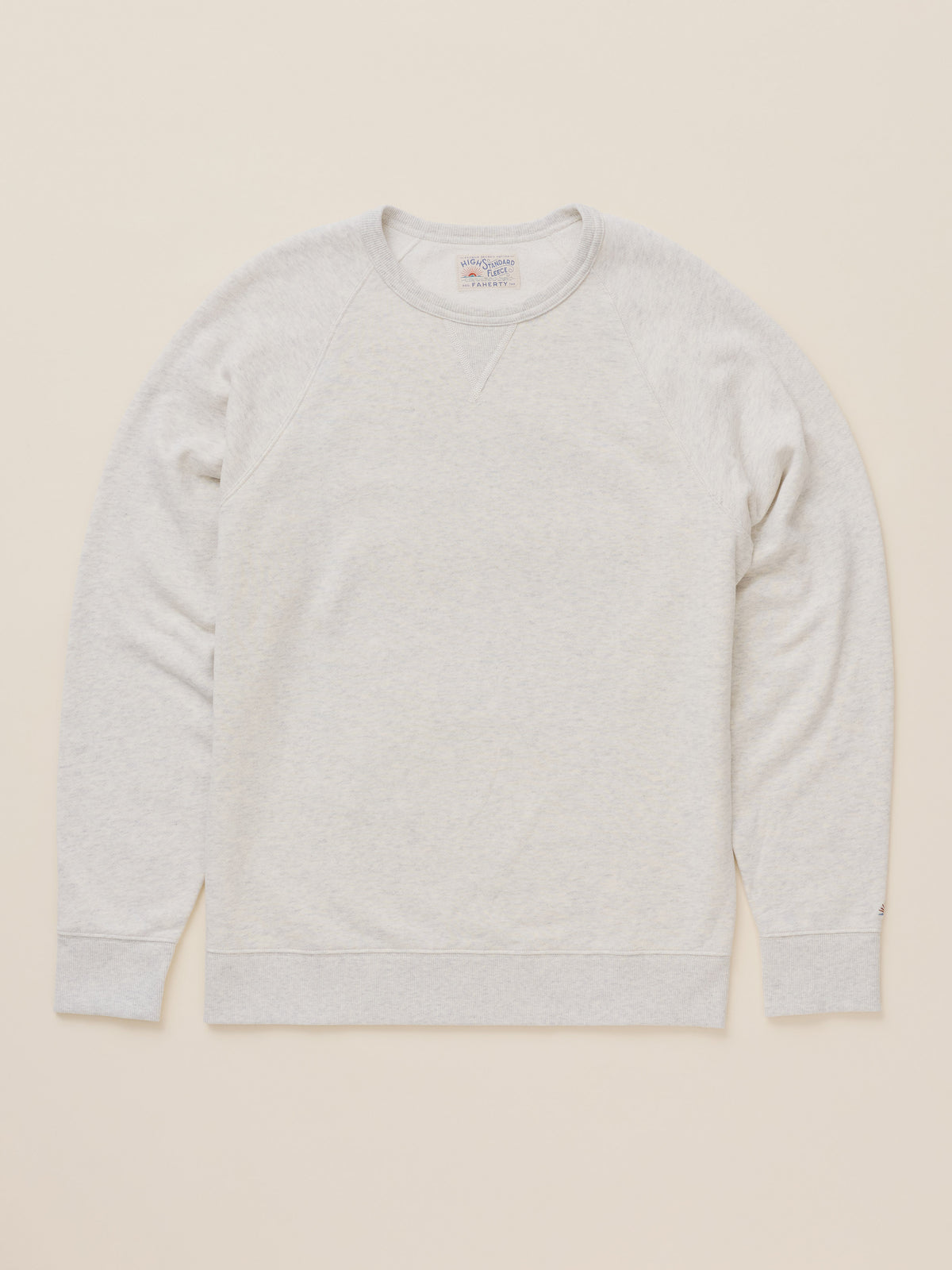 A light heather gray crewneck sweatshirt laid flat against a solid cream-colored background., image 7 of 8