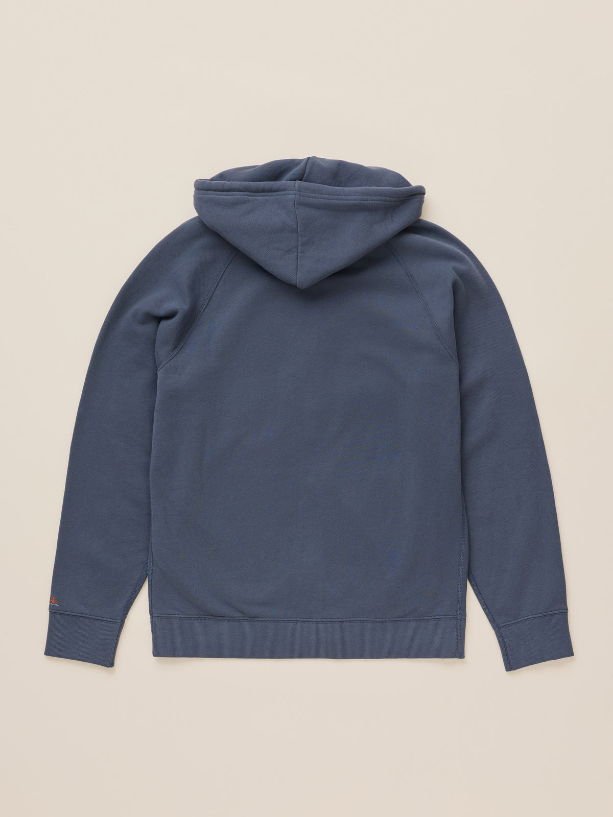 A slate blue pullover hoodie shown from the back, laid flat on a light beige background.