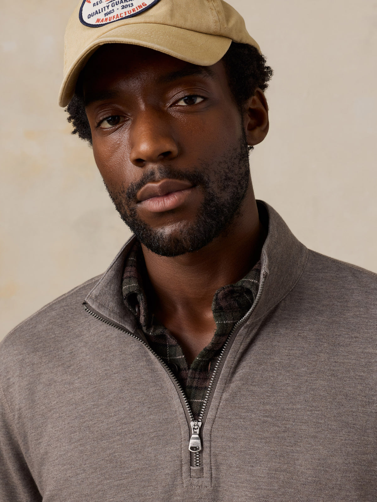 Close up of a man wearing a light brown quarter zip, image 4 of 5