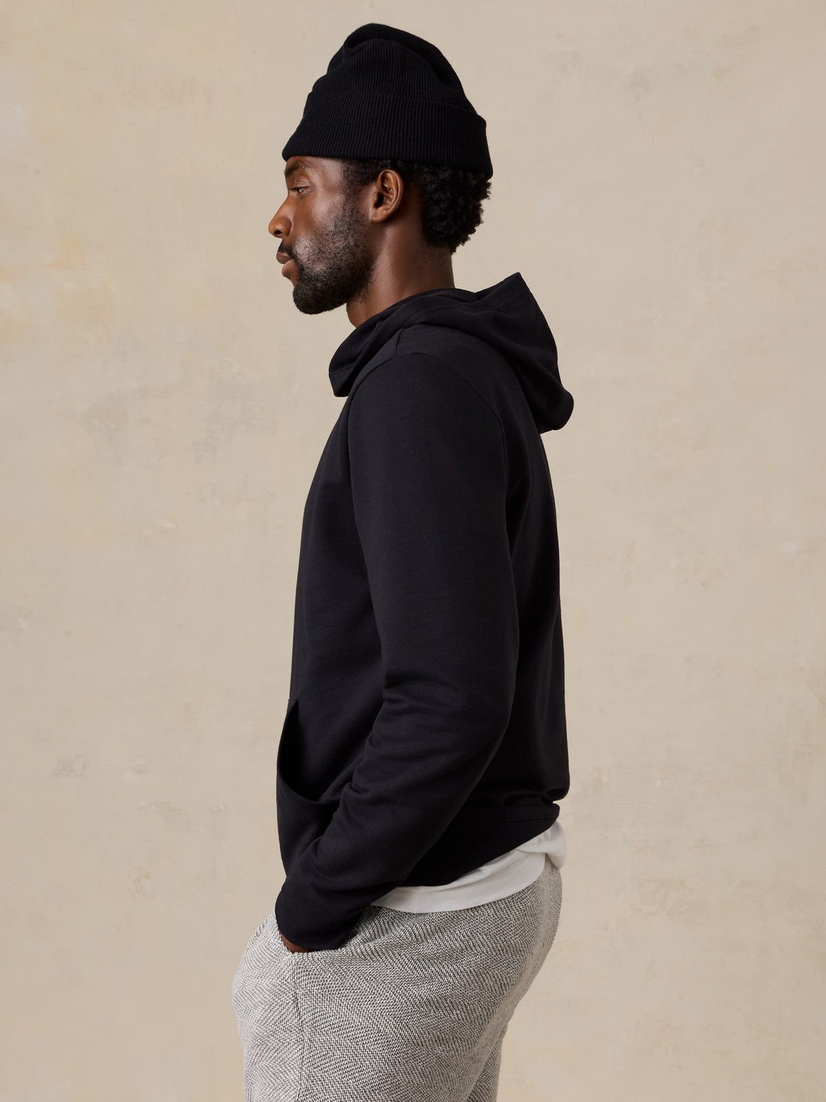 A man wearing a black hoodie and lounge shorts, image 3 of 6