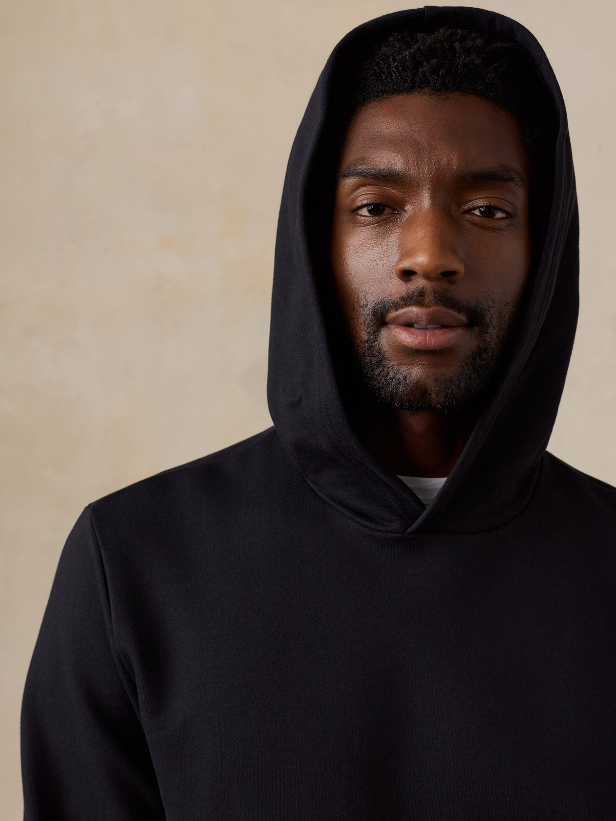 Close up of a man wearing a black hoodie , image 5 of 6