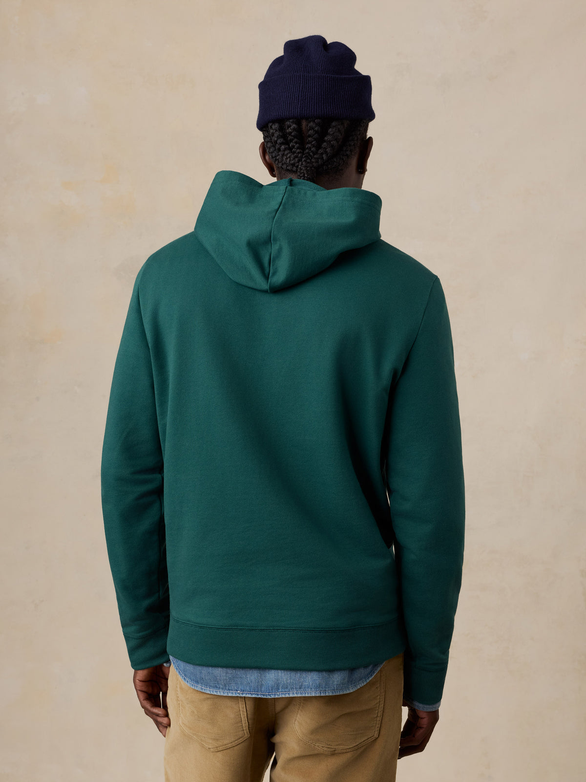 A man viewed from behind wearing a teal hoodie , image 3 of 6