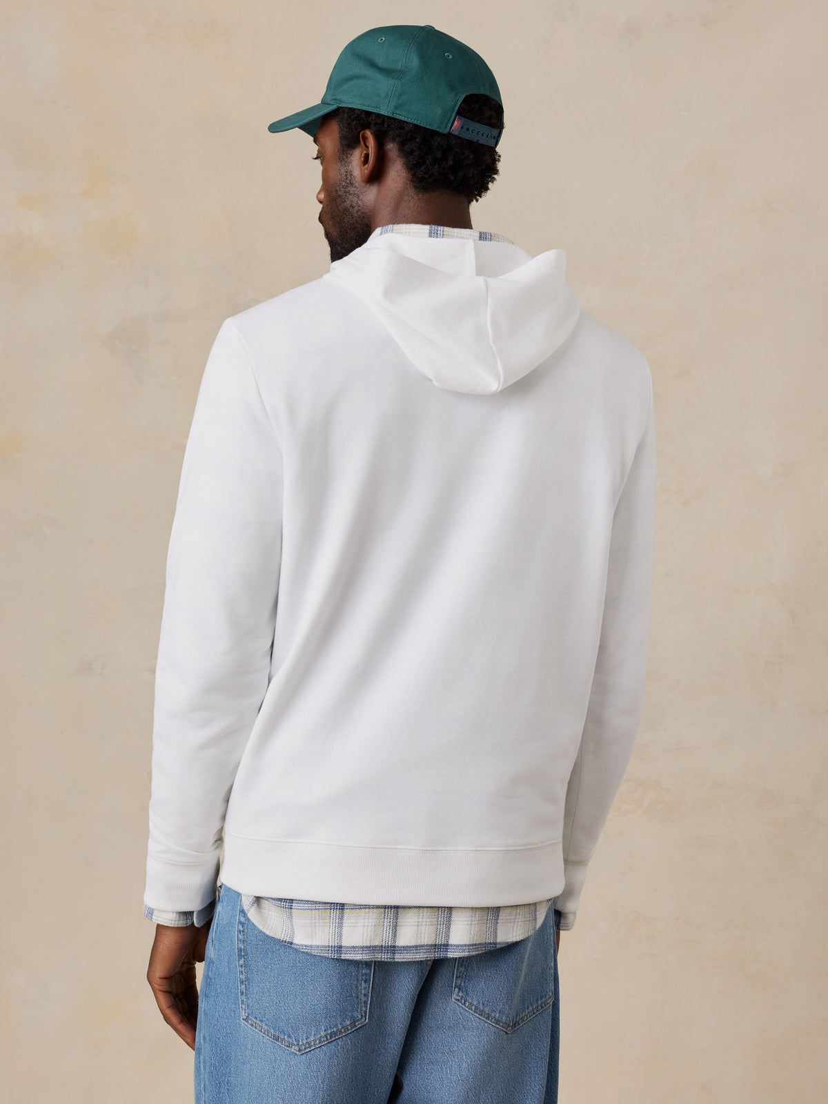 A man viewed from behind wearing a white hoodie , image 5 of 6