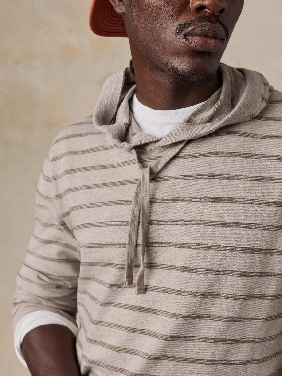 Close up of a man wearing a striped sweatshirt over a white tee, image 5 of 5