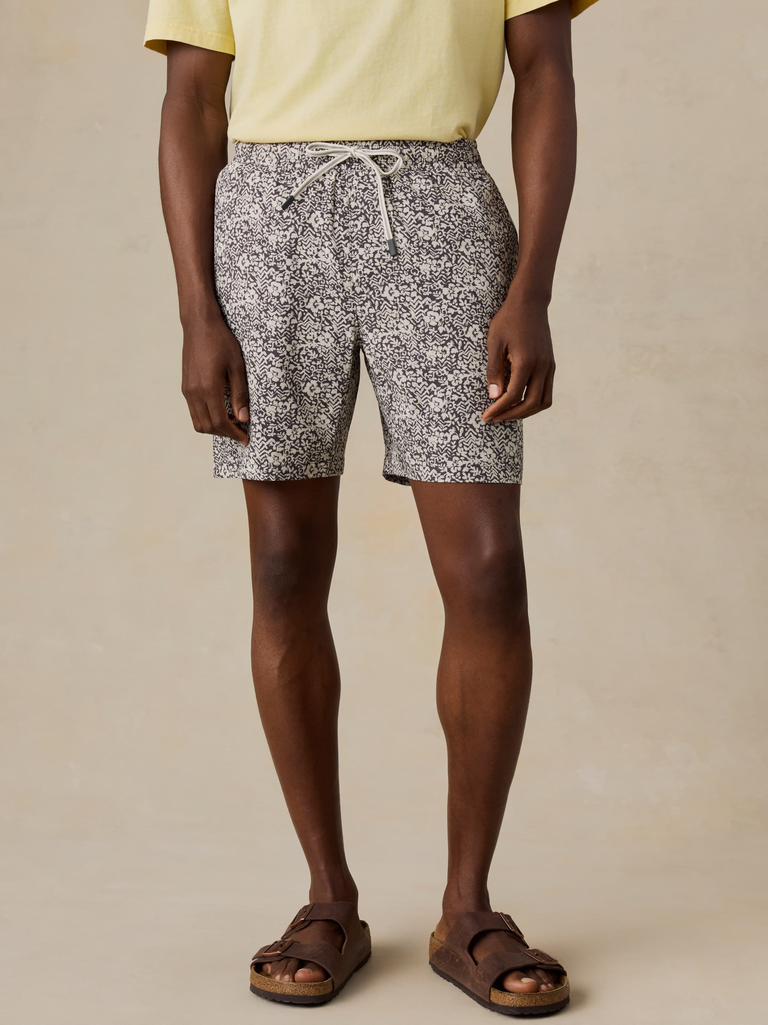 Man wearing black and white patterned shorts on a beige background