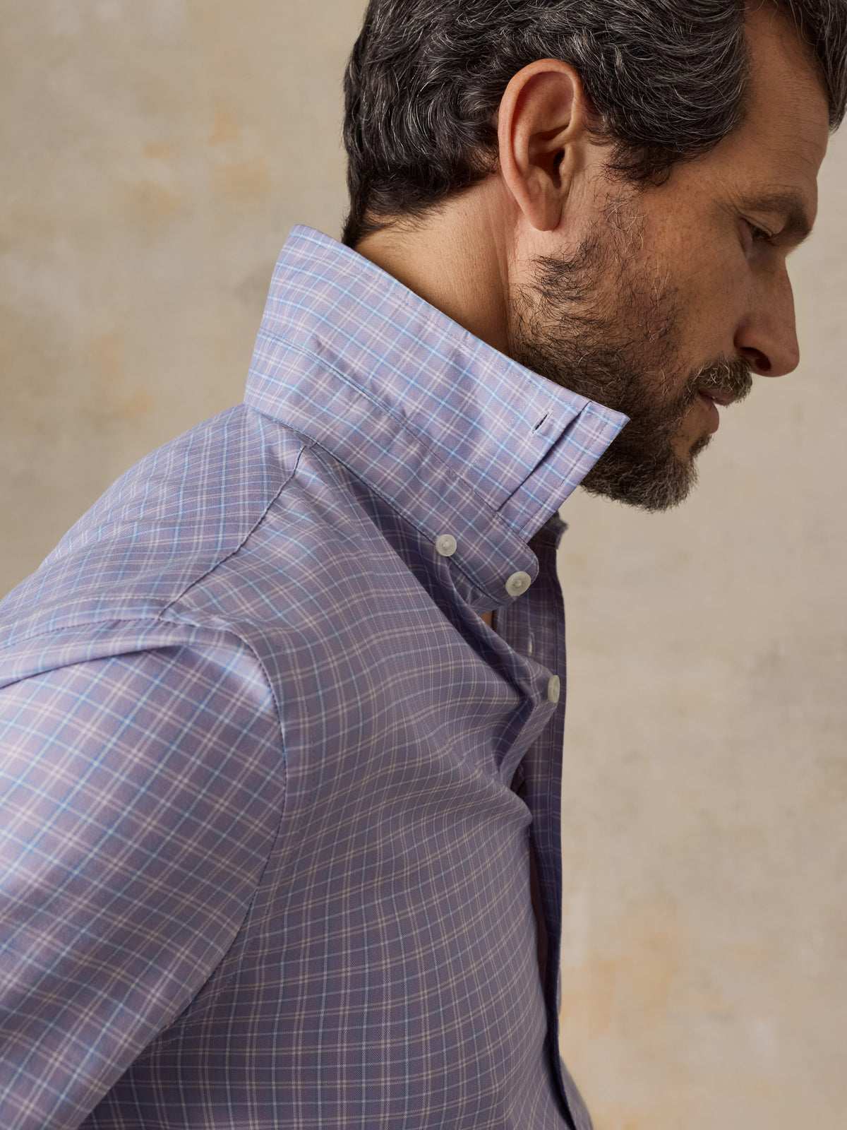 Close up side profile of a man wearing a light purple plaid shirt , image 4 of 5
