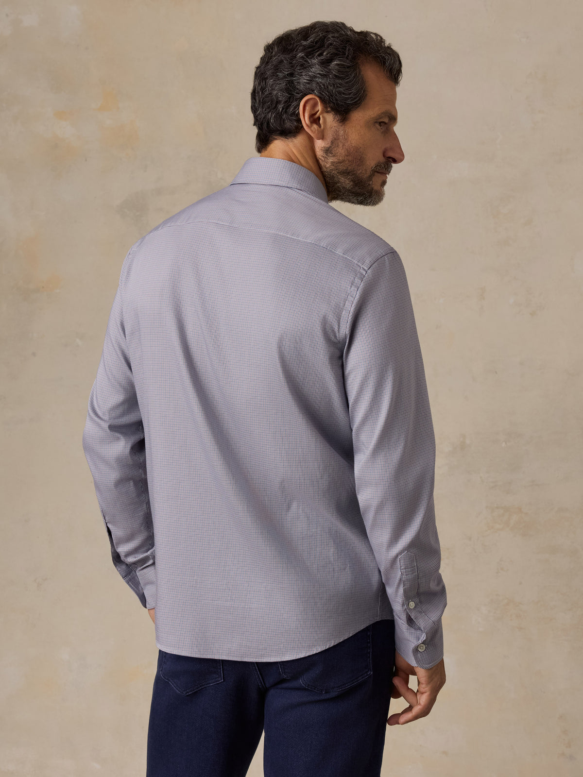 A man wearing a blue button up shirt and blue jeans, image 2 of 5