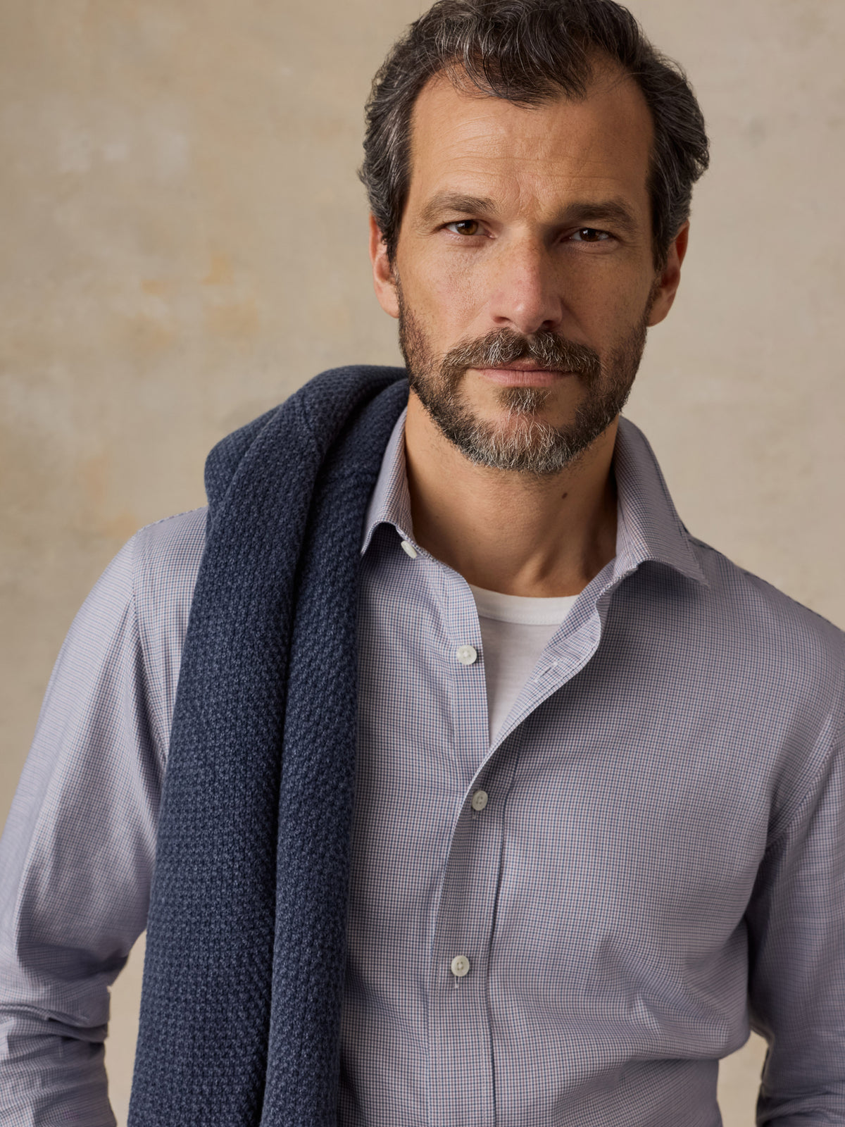 A man wearing a blue button up shirt , image 4 of 5