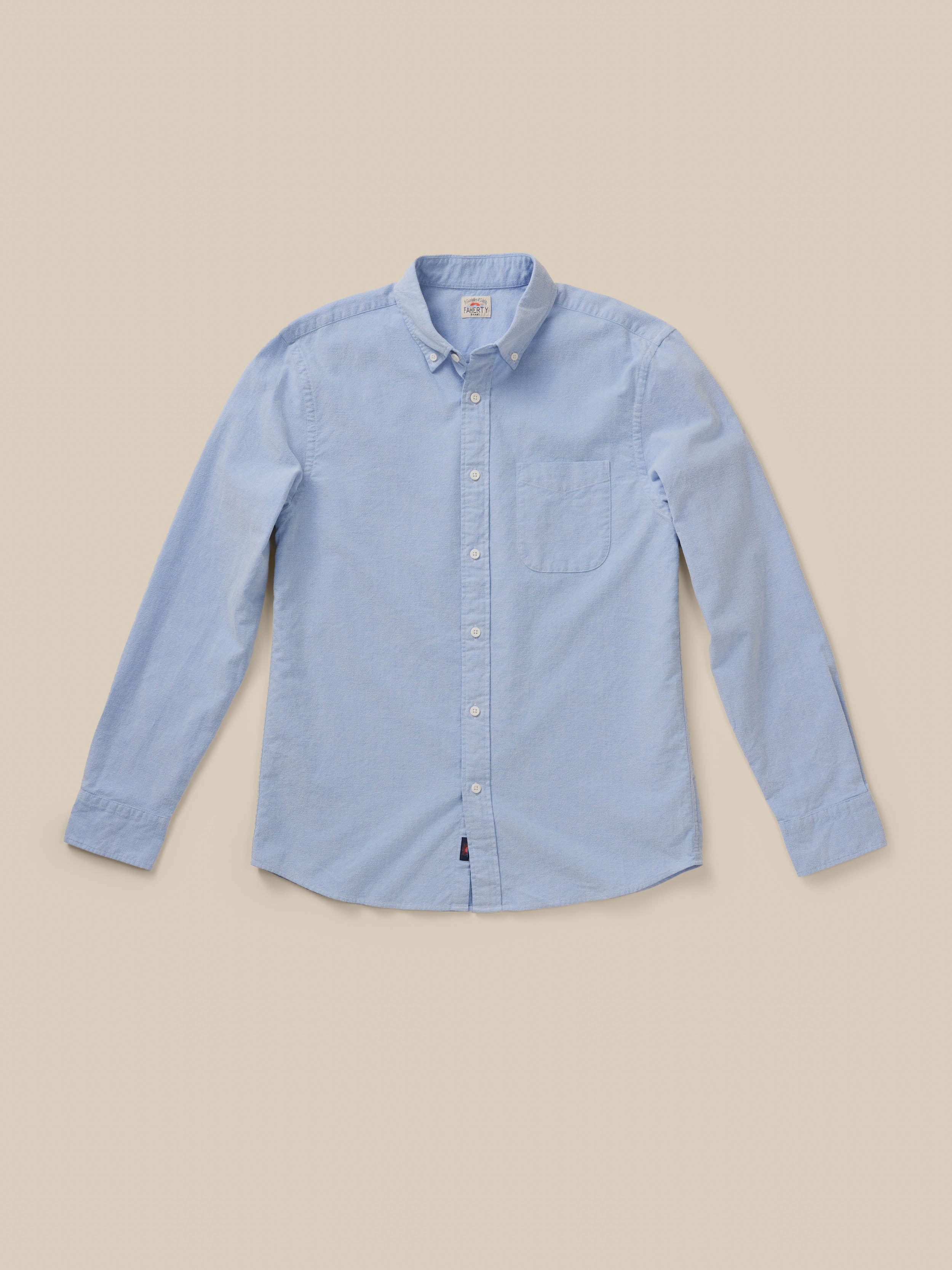 Light blue long sleeve button down shirt against a beige background, image 7 of 9