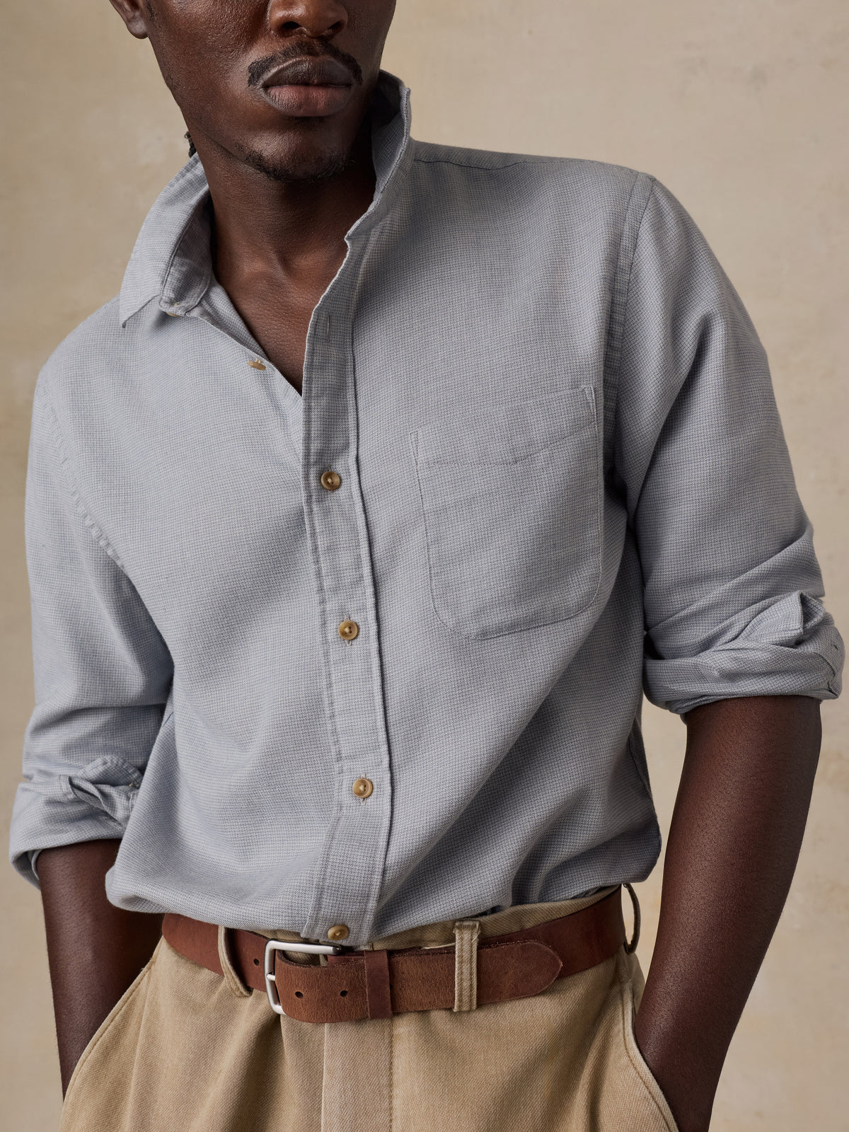 A man wearing a grey shirt and beige pants, image 3 of 5