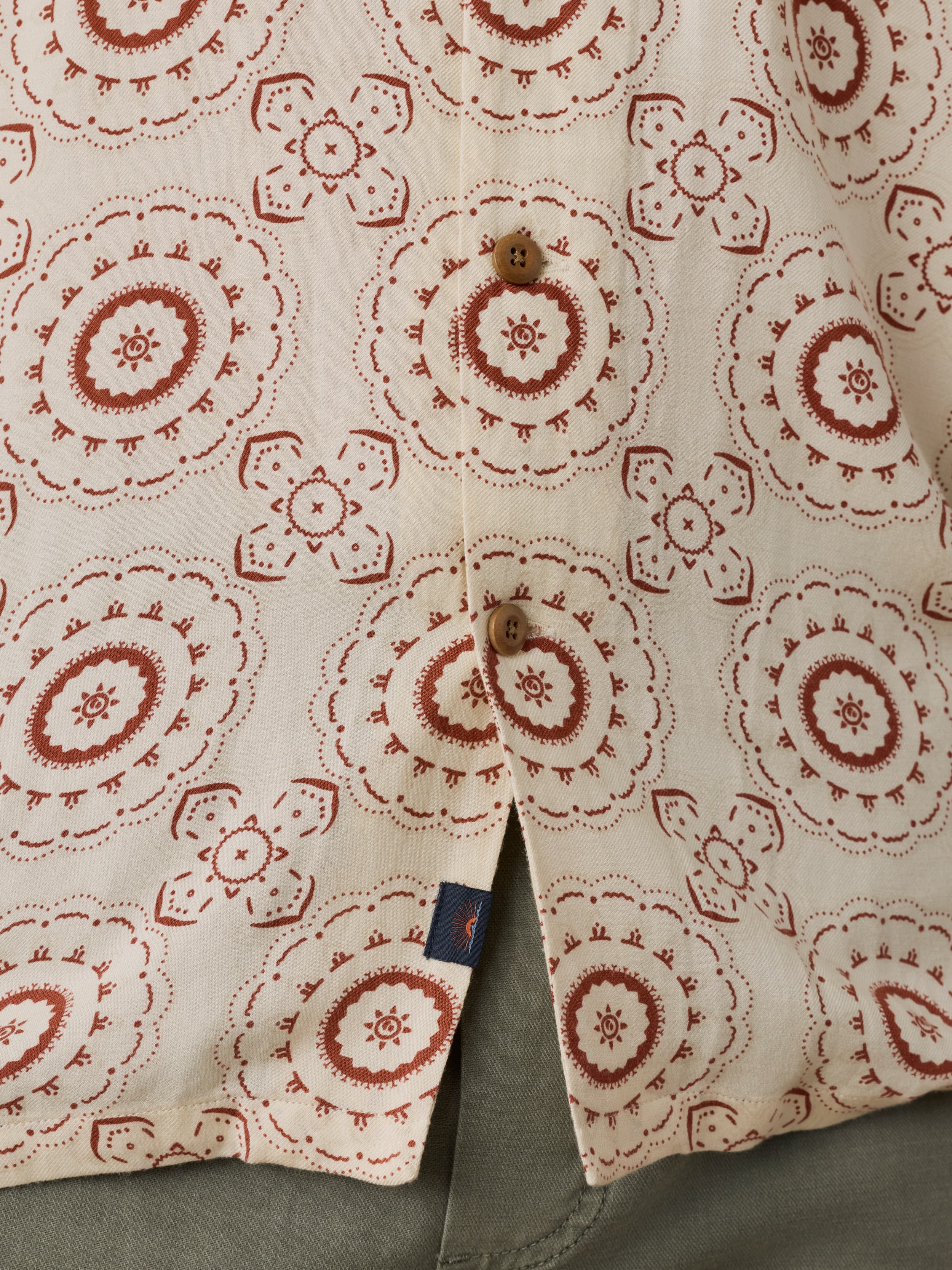 Close-up of a shirt with red floral pattern on beige fabric