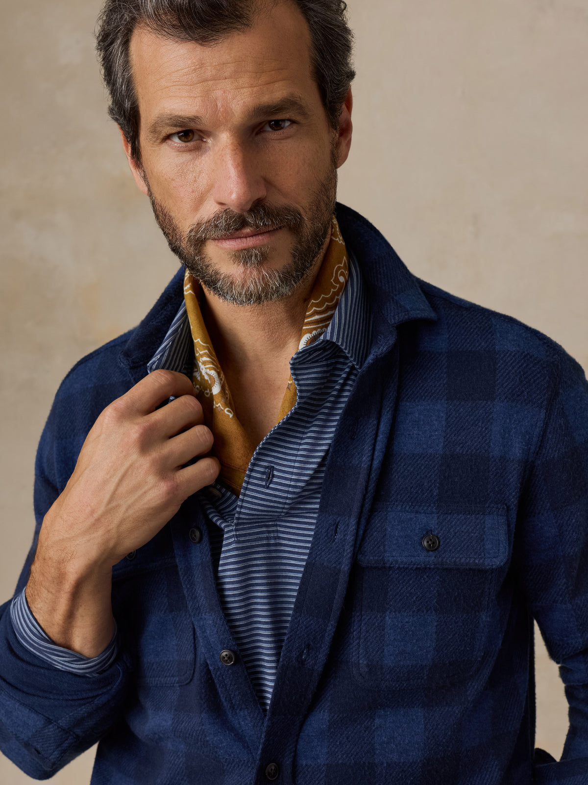 Close up of a man wearing a blue checkered flannel and blue jeans, image 3 of 5