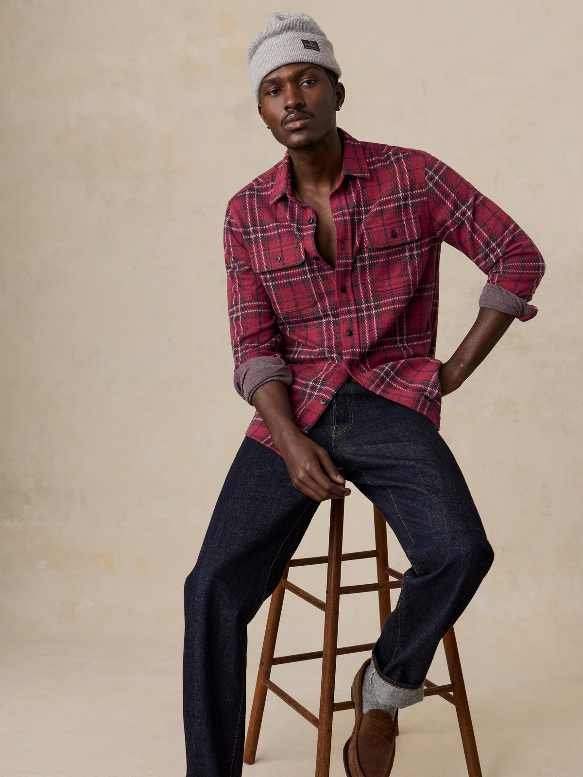 A man wearing a red button up shirt and jeans, image 5 of 6
