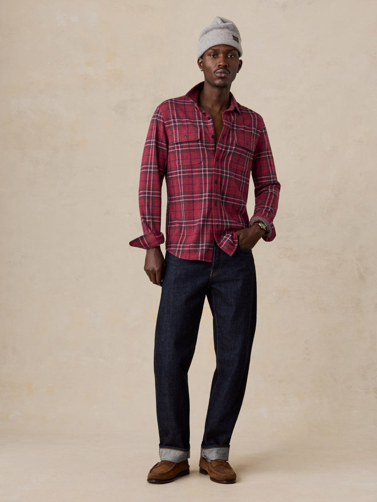 A man wearing a red button up shirt and dark jeans, image 6 of 6