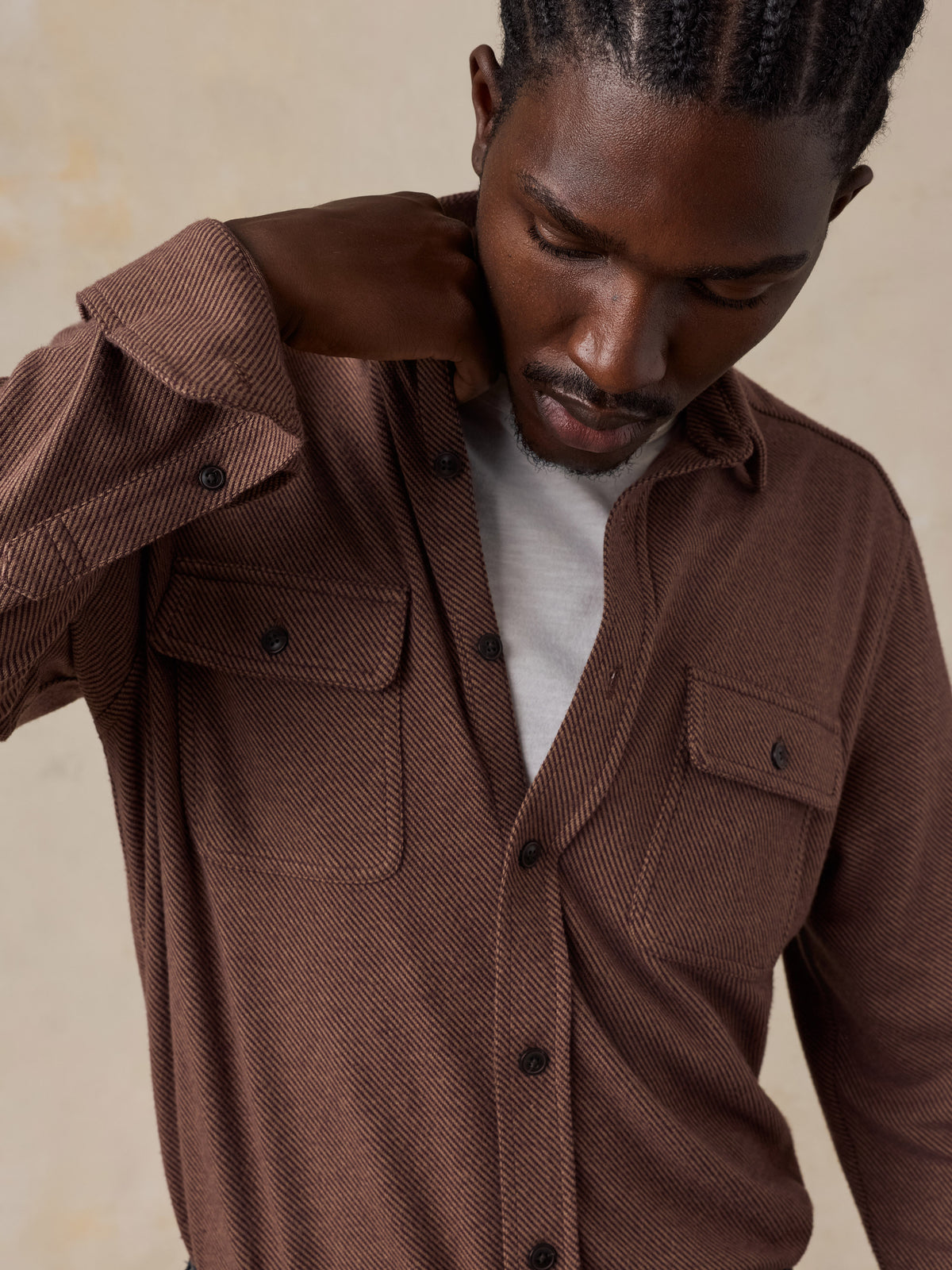 Close up of a man wearing a brown shirt over a white tee, image 5 of 5
