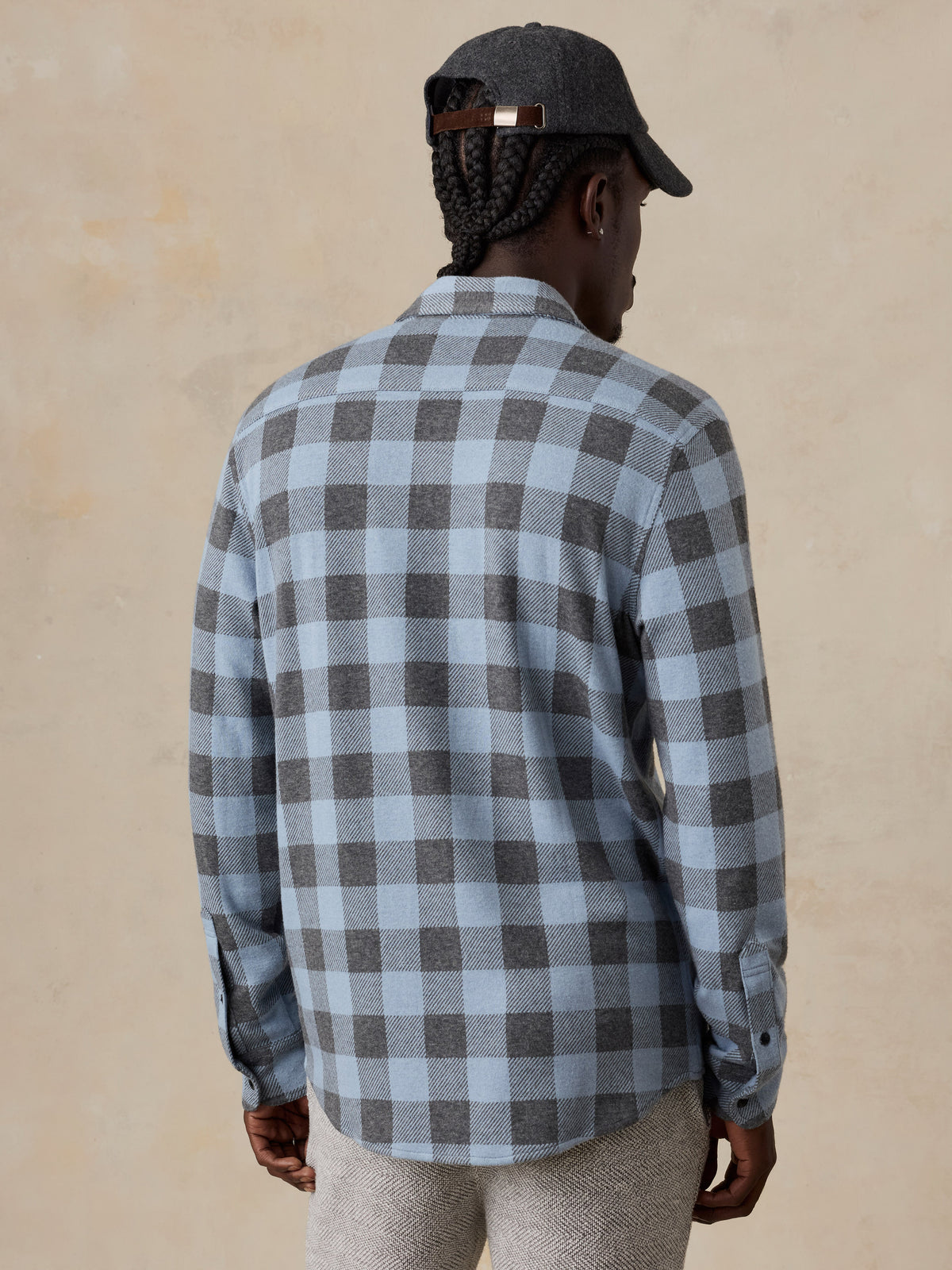 A man viewed from behind wearing a blue plaid shirt, image 5 of 5