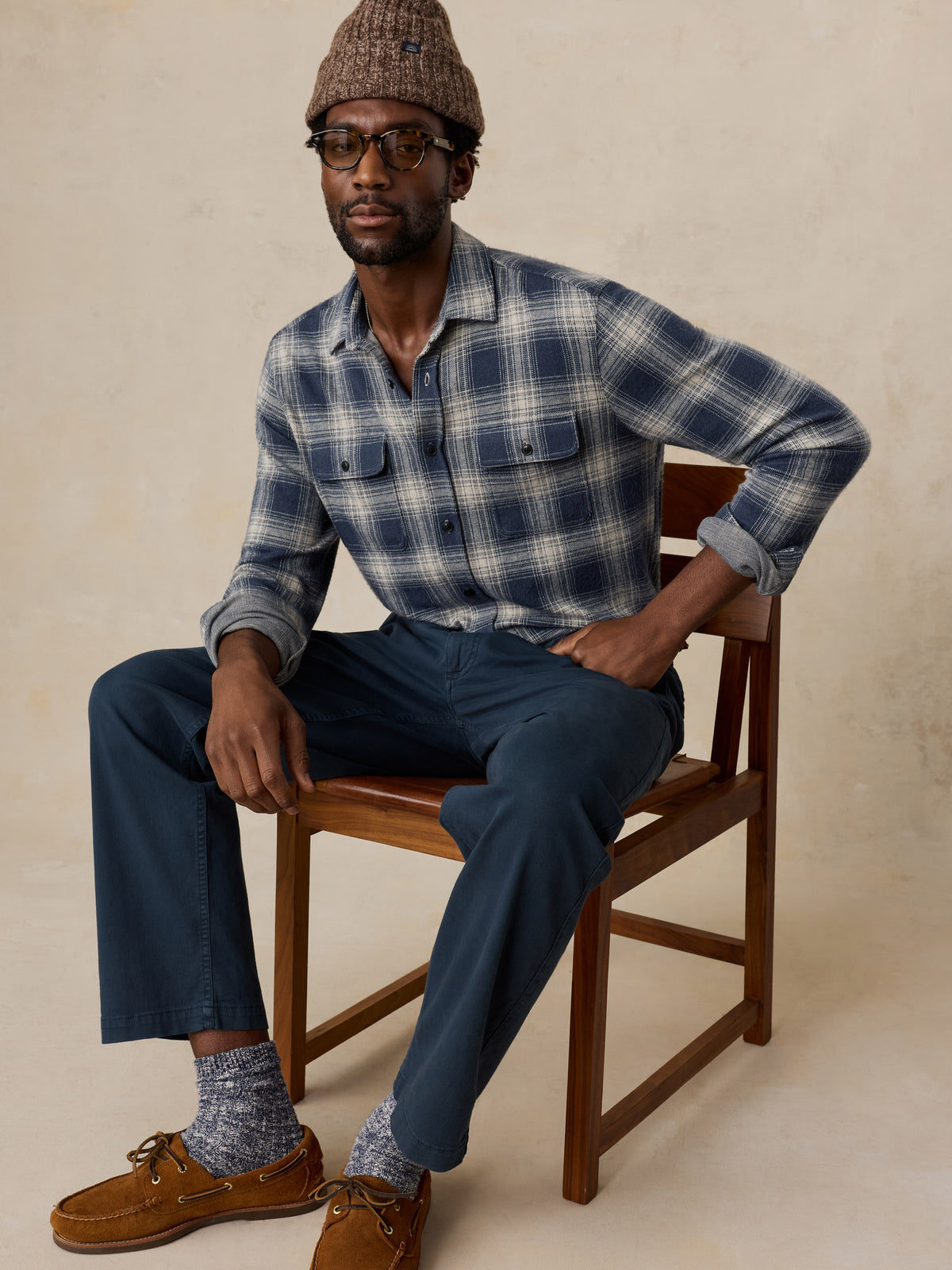 A man wearing a blue button up shirt and blue chino pants, image 4 of 5