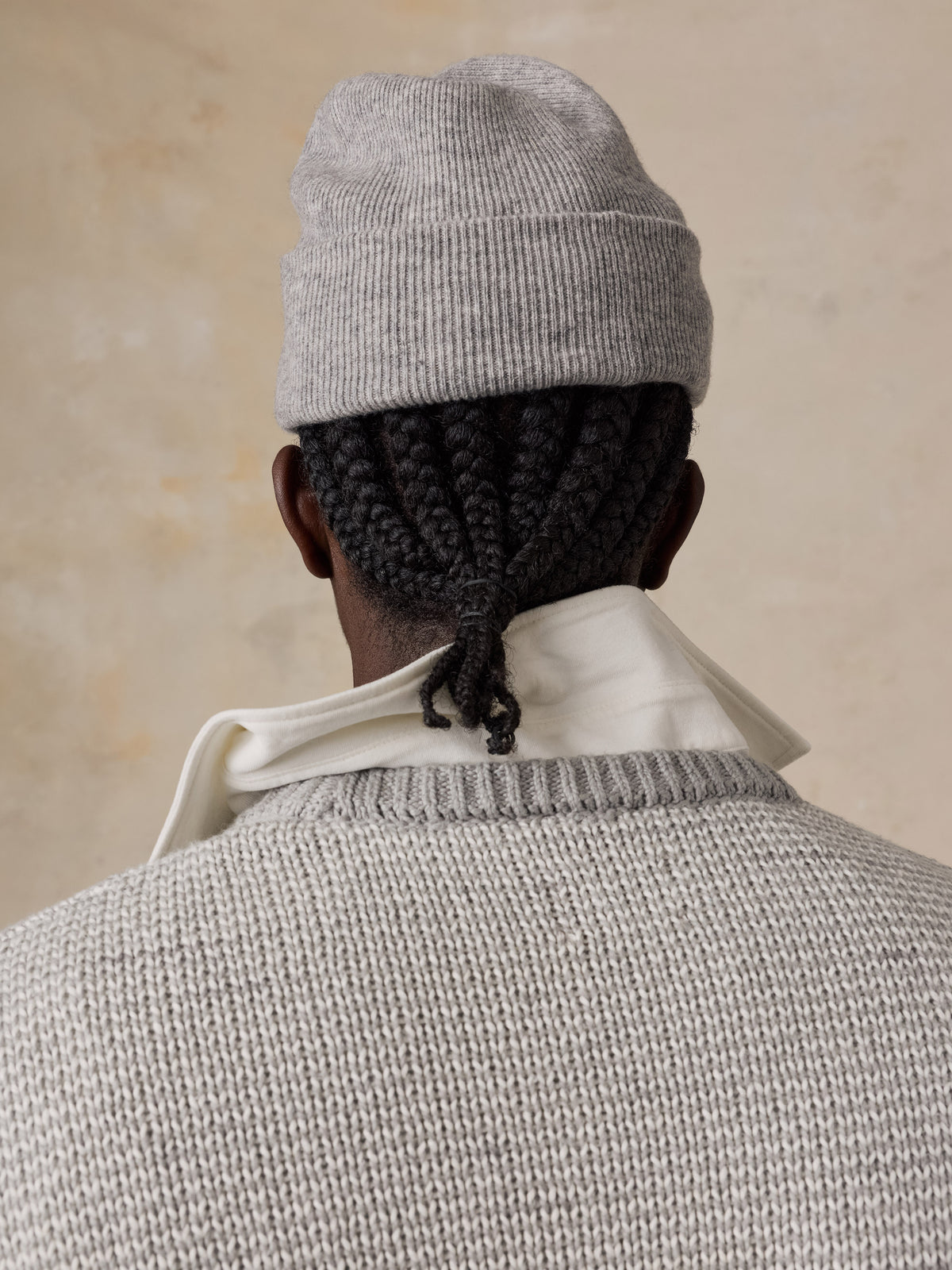 Man viewed from the back wearing a light grey sweater over a white shirt, image 5 of 5