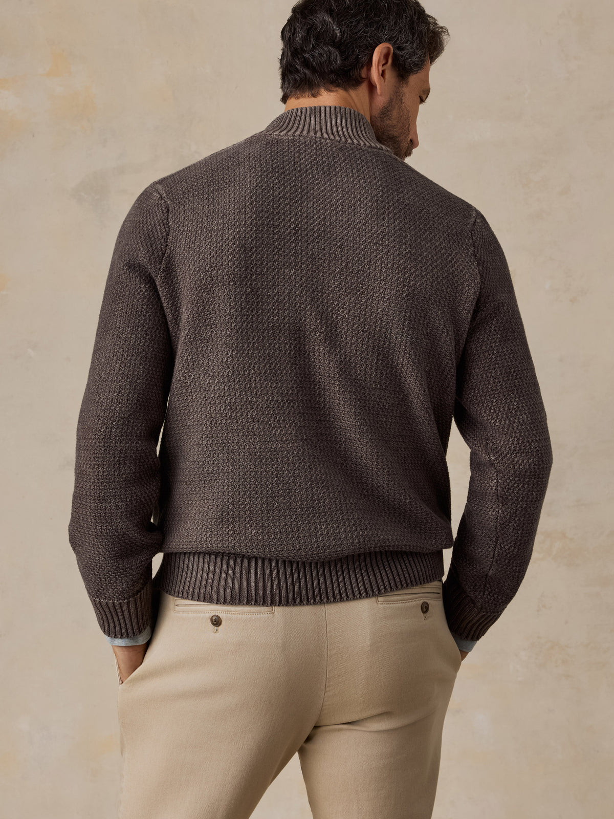 Man viewed from the back wearing a brown sweater and chino pants , image 4 of 5