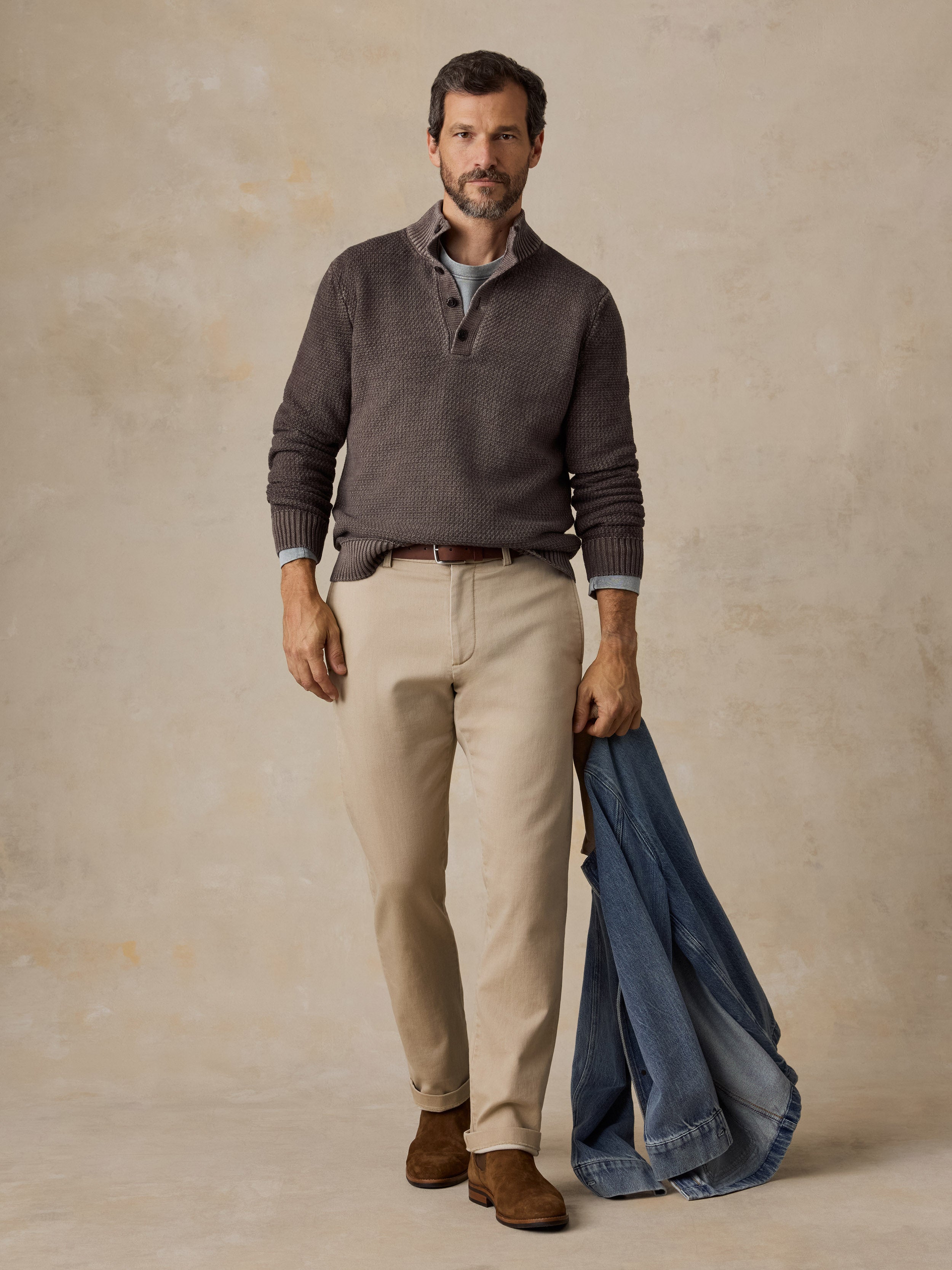 Man wearing a brown sweater and chino pants