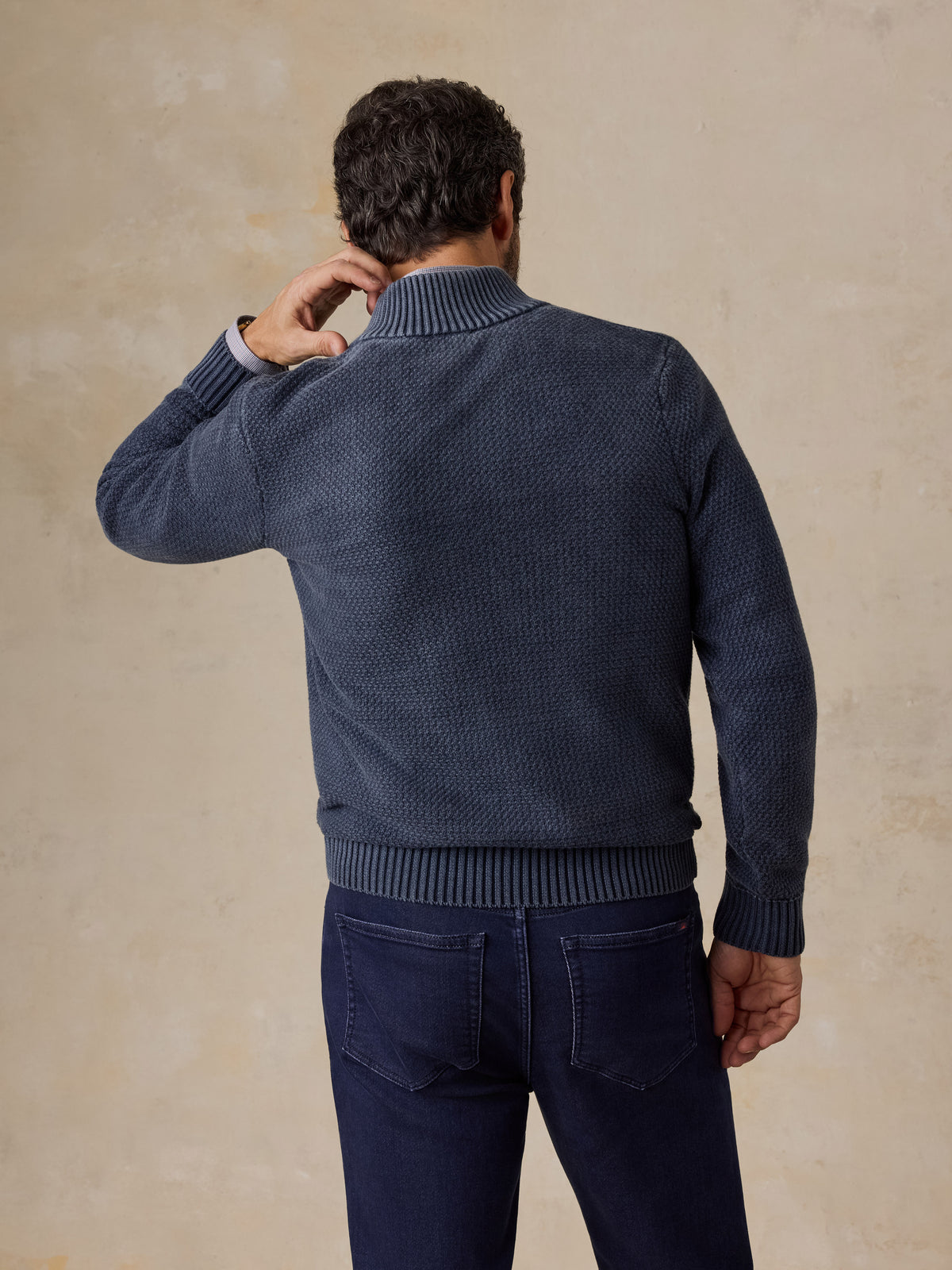 Man viewed from the back wearing a blue button up sweater and navy pants, image 2 of 5