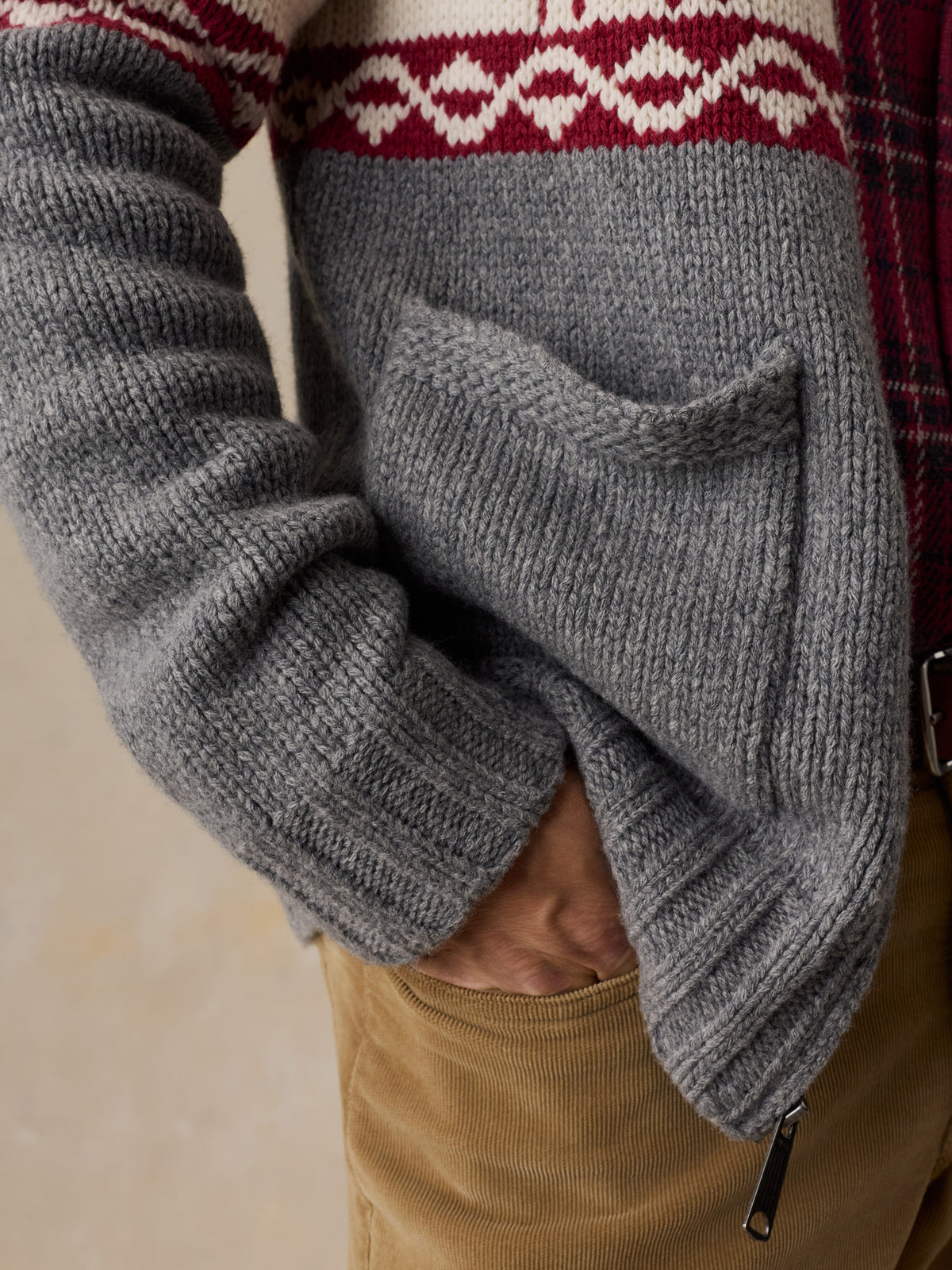 Close up of a man wearing a printed wool cardigan and tan pants, image 3 of 5