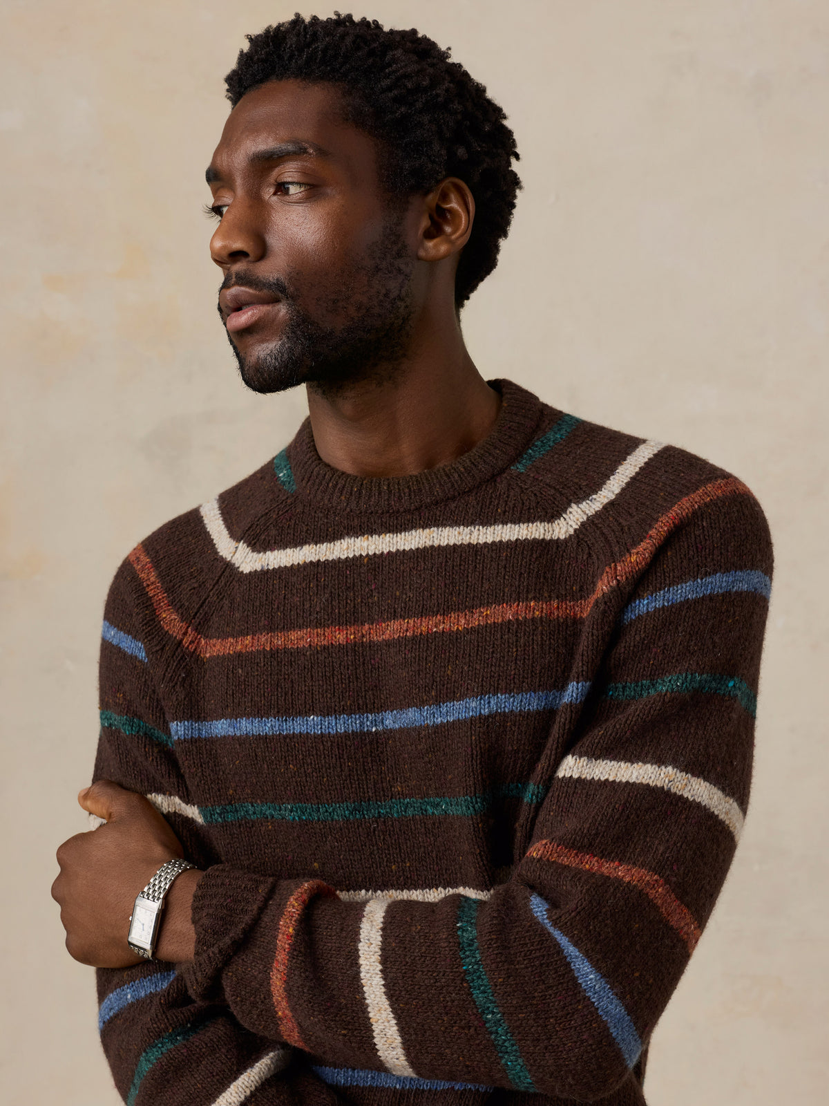 Close up of a man wearing a brown striped sweater, image 6 of 6