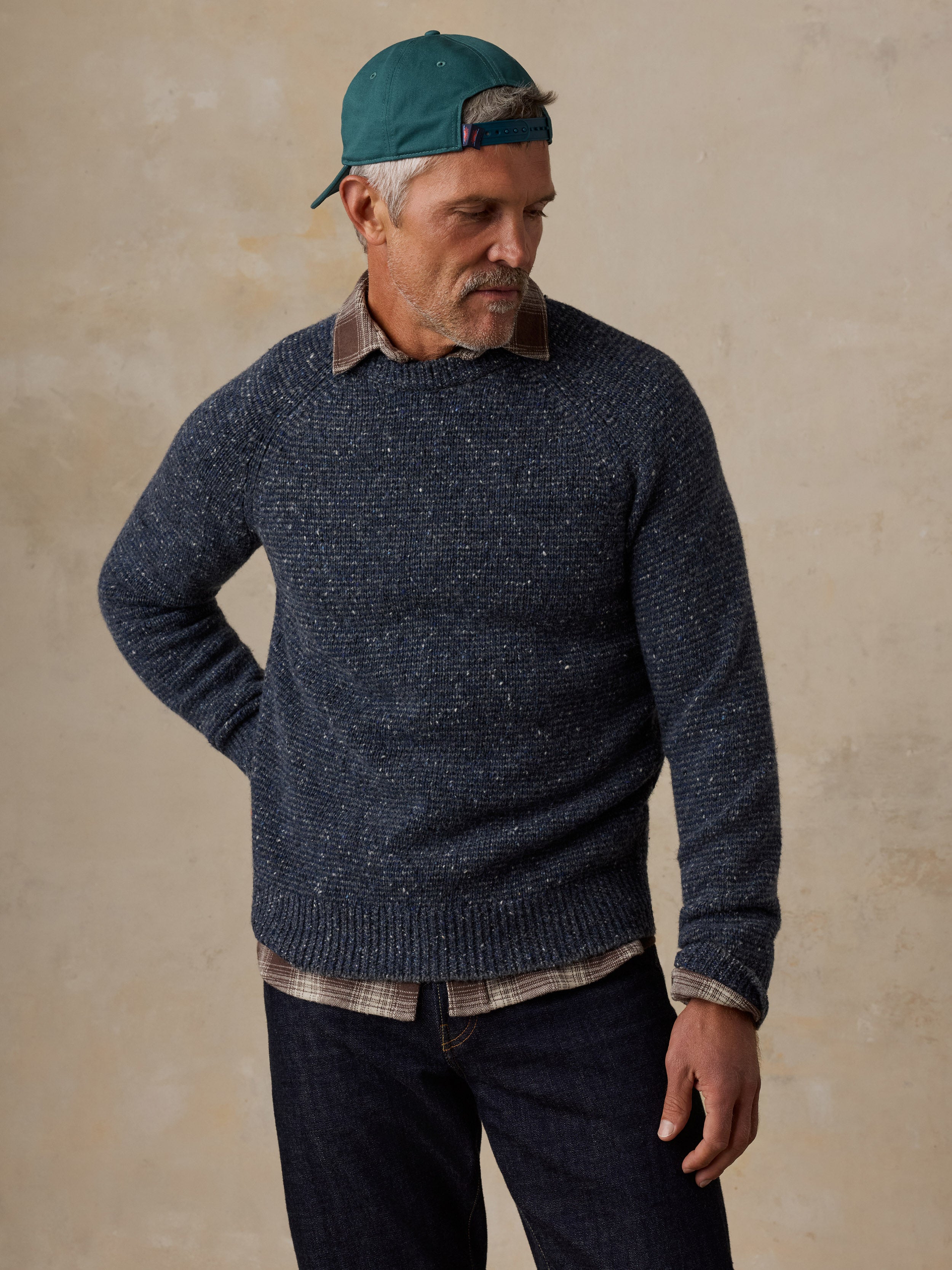 A man wearing a blue sweater and jeans