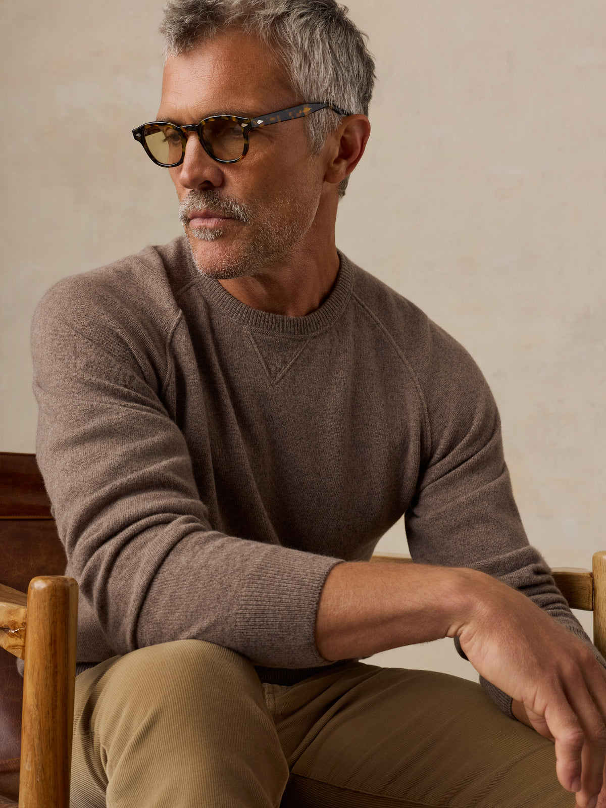 A man wearing a brown sweater and sunglasses, image 4 of 5