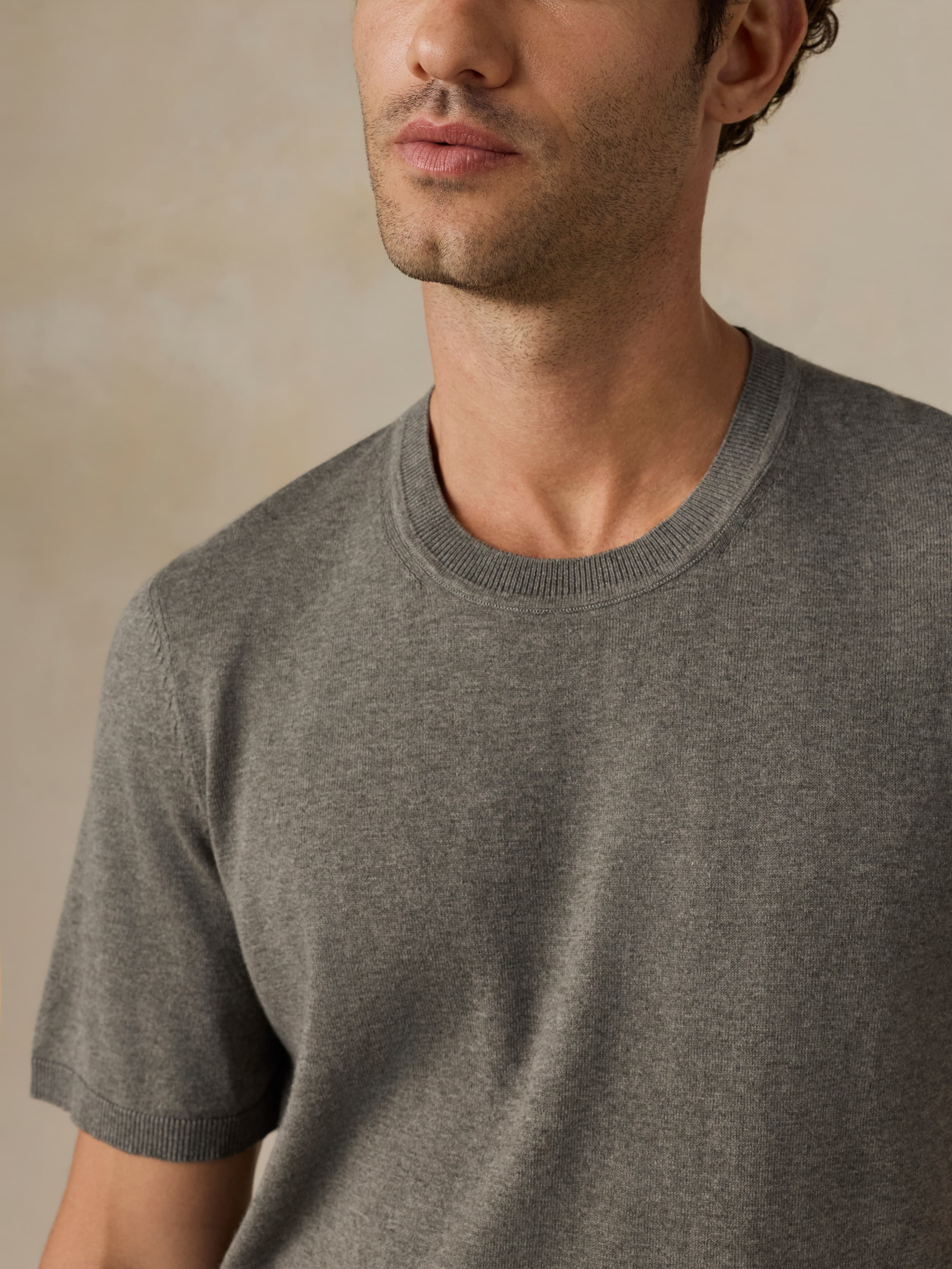 Man wearing a green t-shirt against a beige background