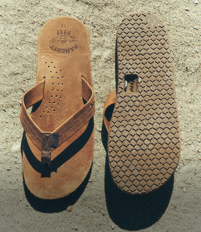 Faherty X Reef sandals lying on the sand