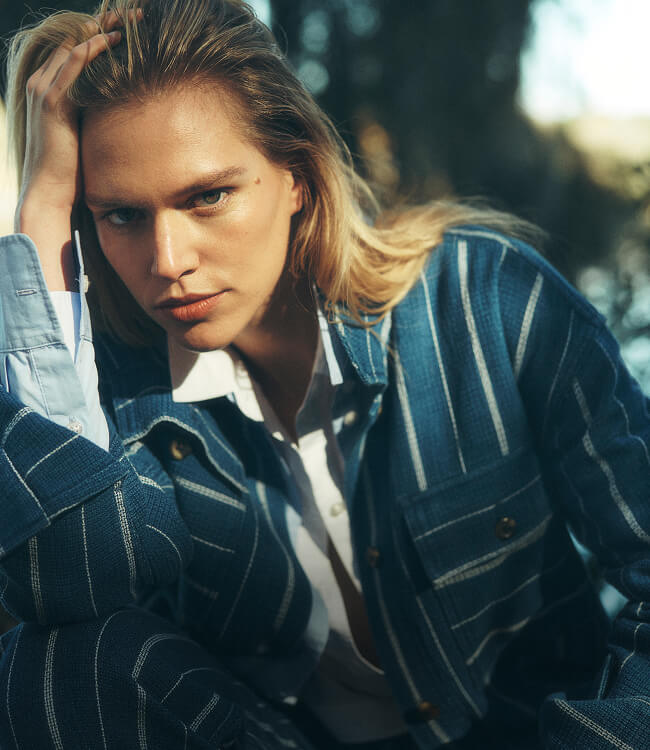close up of female model wearing a linen striped suit paired with a chambray shirt