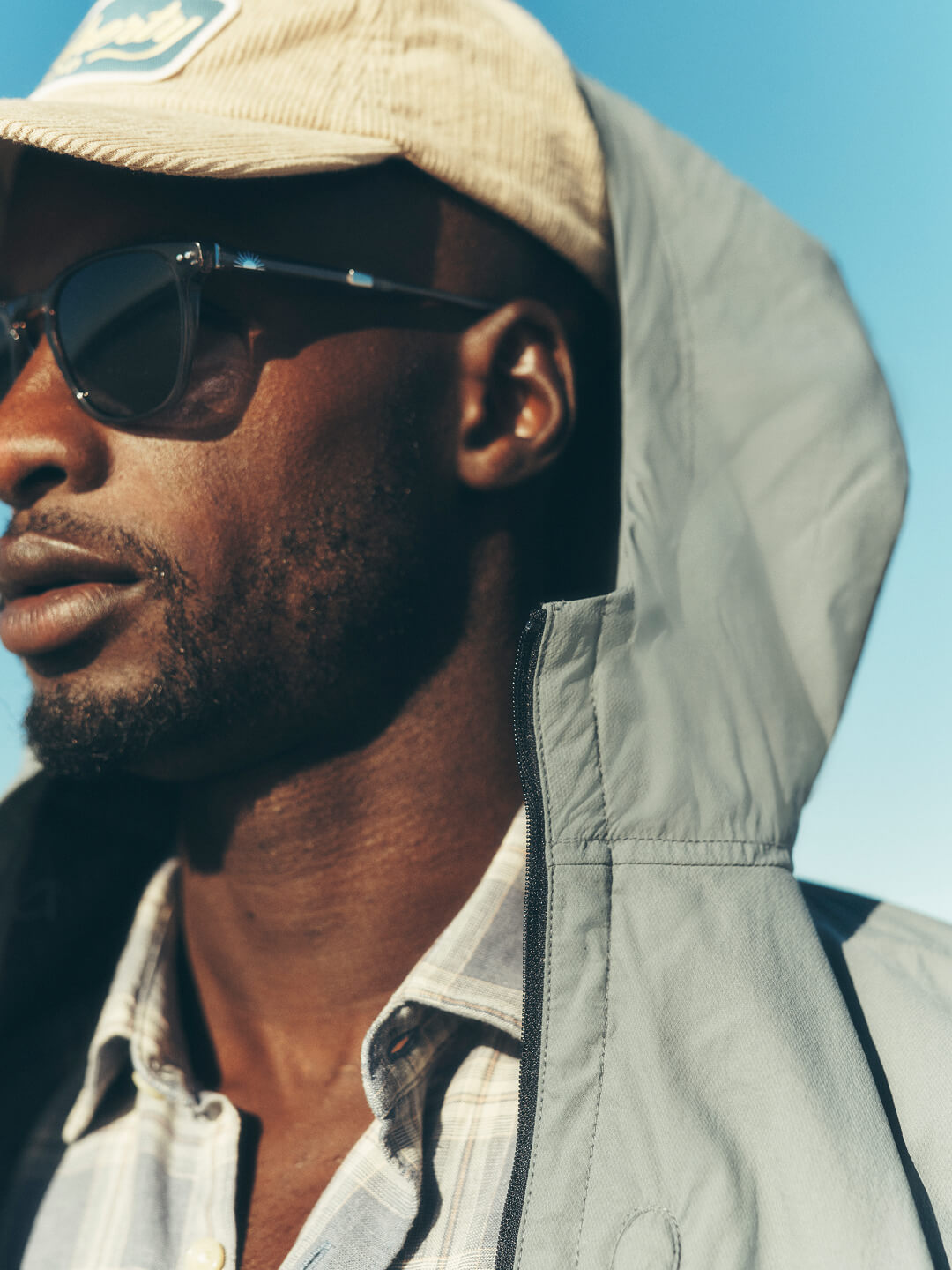 A close of up a male model wearing a corduroy cap and sunglasses