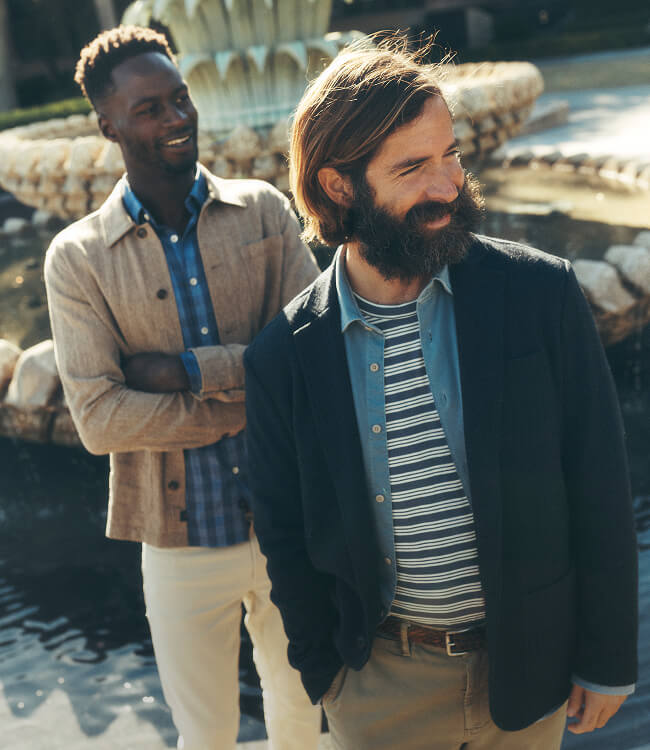 Two men standing in front of a fountain wearing the Faherty spring 26 collection