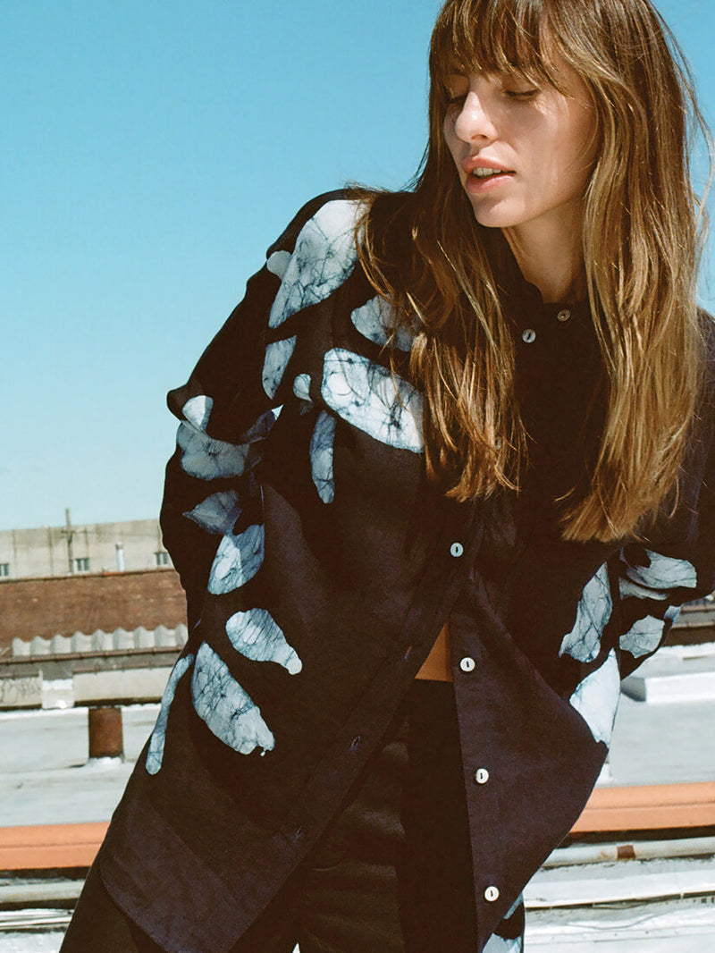 Female model posing on a rooftop in a Mia Mud resist print shirt