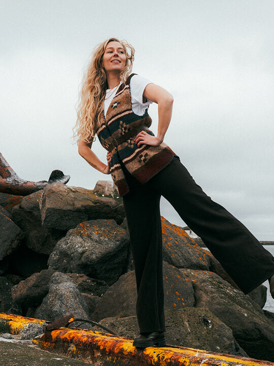 Woman posing on a rock with a native knitter sweater vest