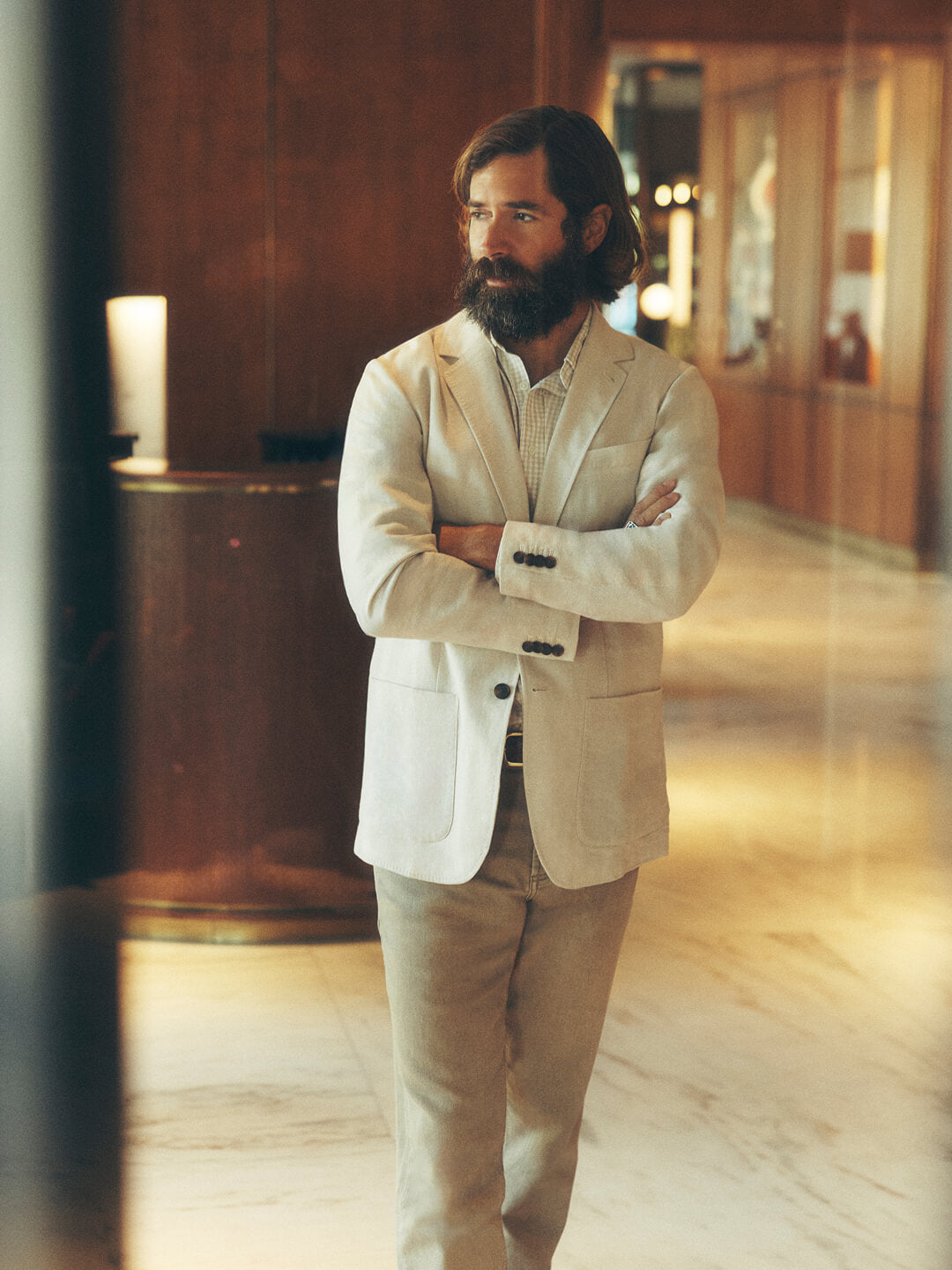 a man wearing a white linen blazer, a movement shirt and khaki pants