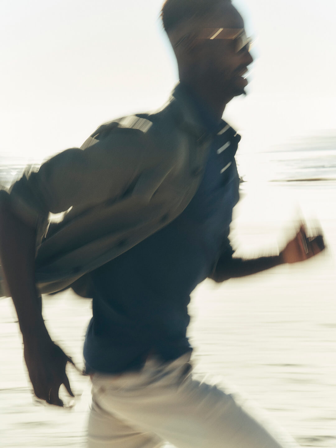 a blurry photo of a man running down the beach