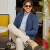 Founder Mike Faherty sitting at an outdoor cafe on a sunny day, wearing the Movement blazer, Shirt, and 5-Pocket Pant.