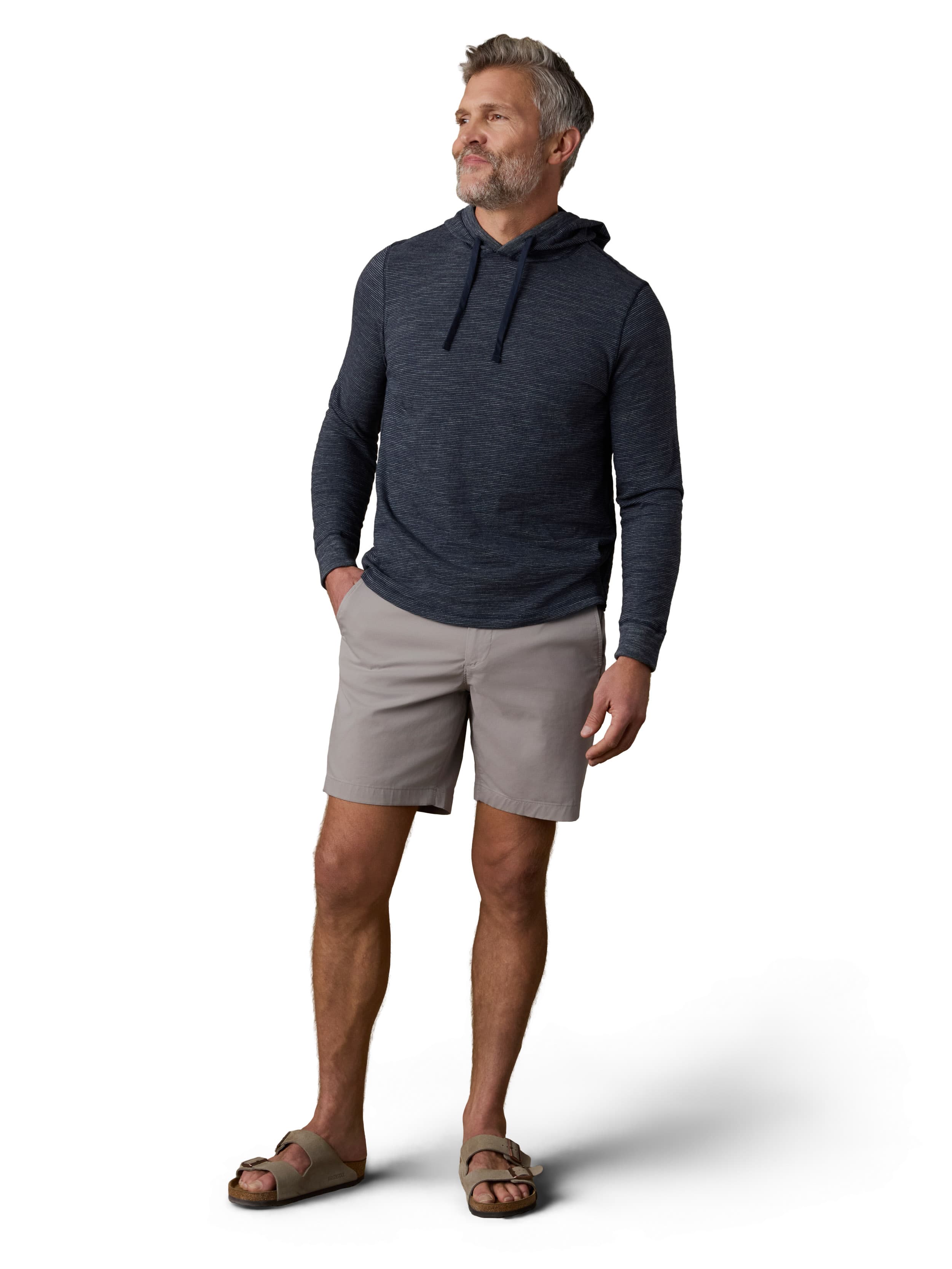 A man wearing a blue hoodie, grey shorts, and birkenstocks