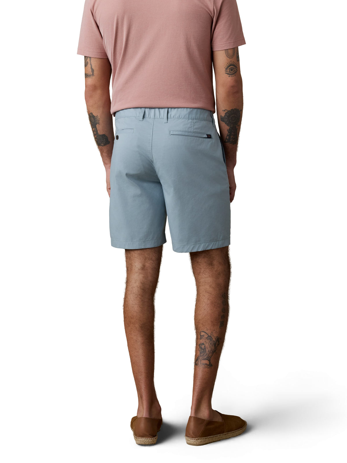 A man viewed from behind wearing a pink polo and light blue shorts, image 3 of 3