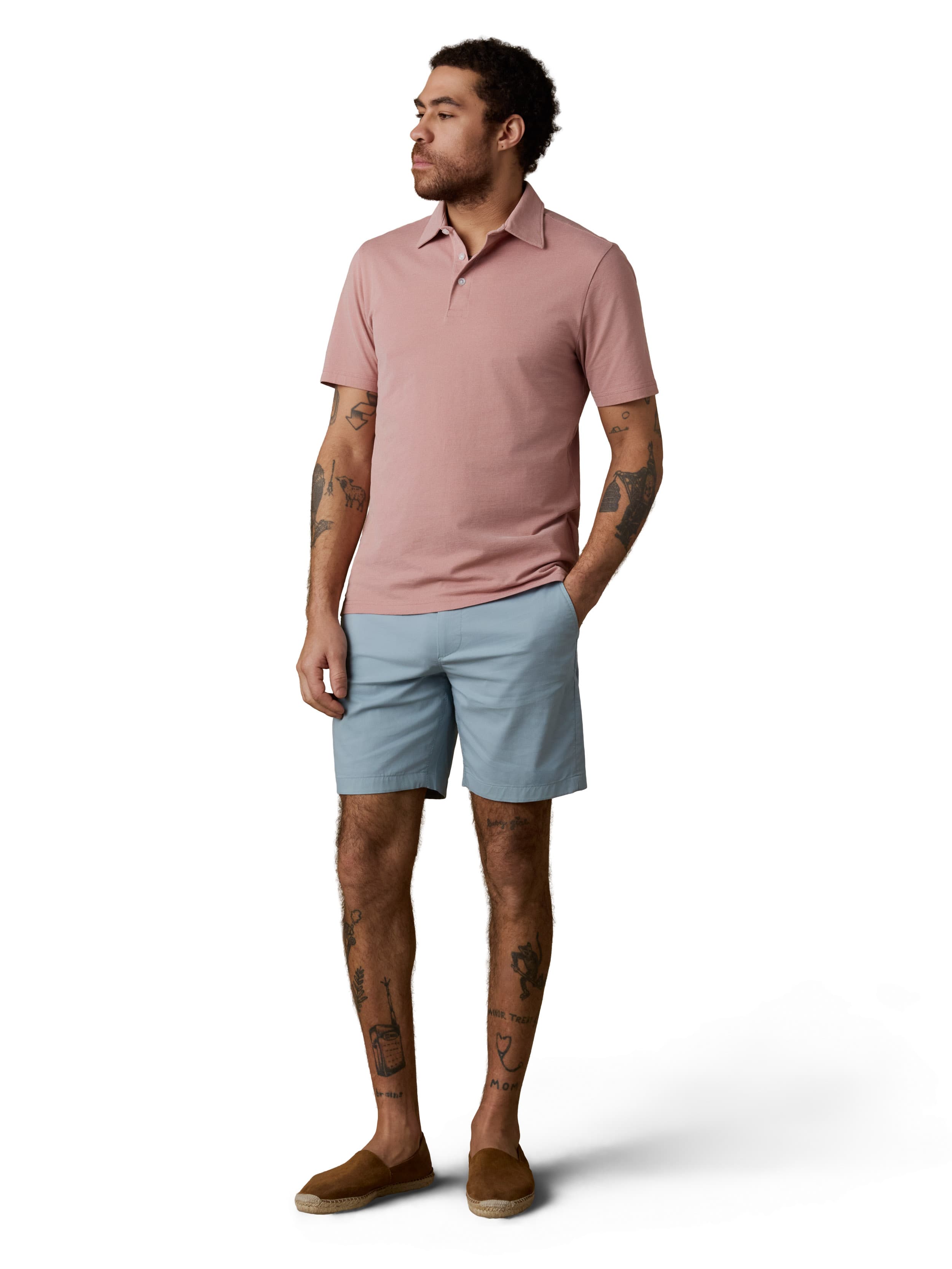 A man wearing a pink polo and light blue shorts