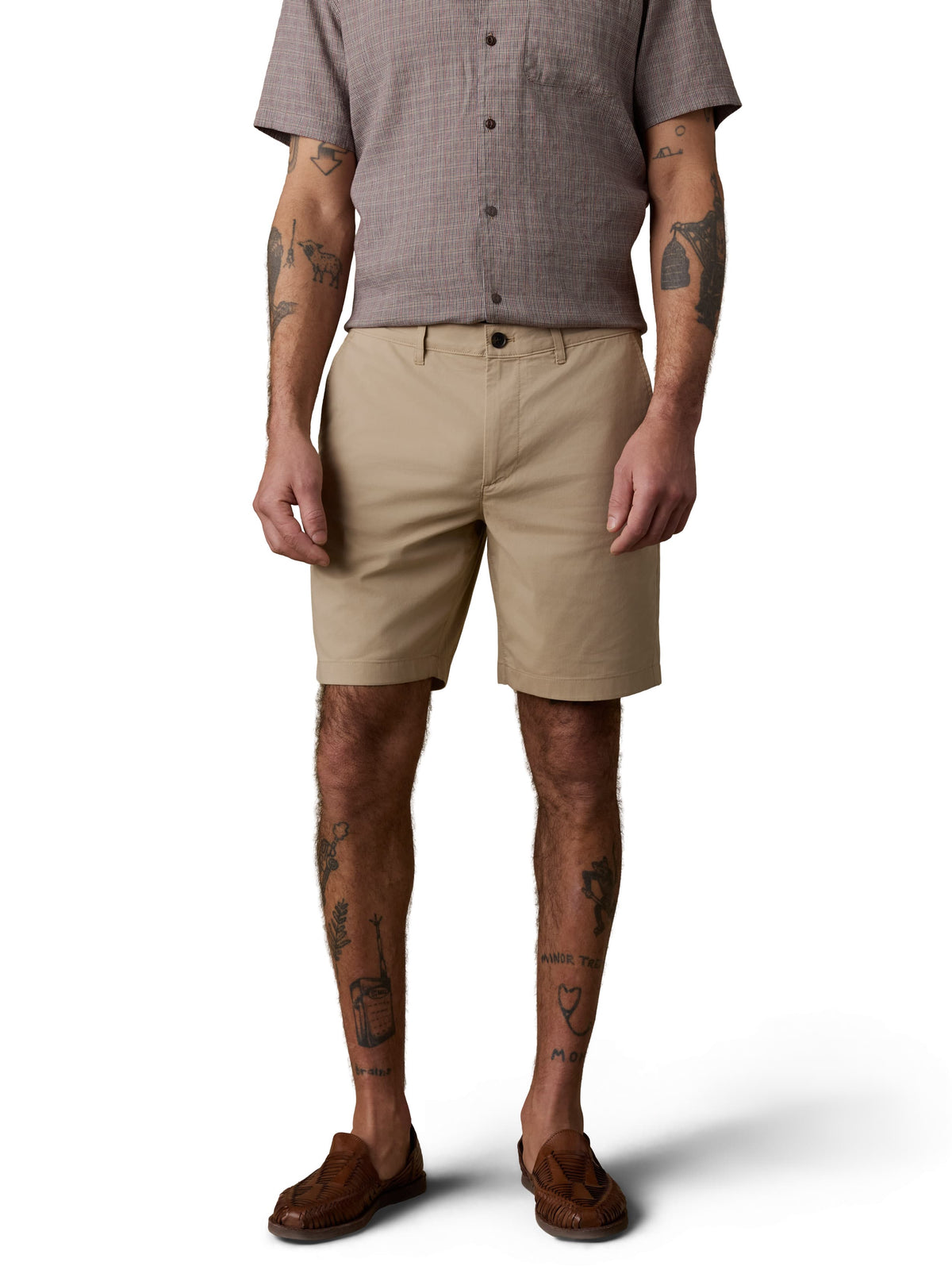 A man wearing a brown button up shirt, beige shorts, and brown shoes, image 2 of 3