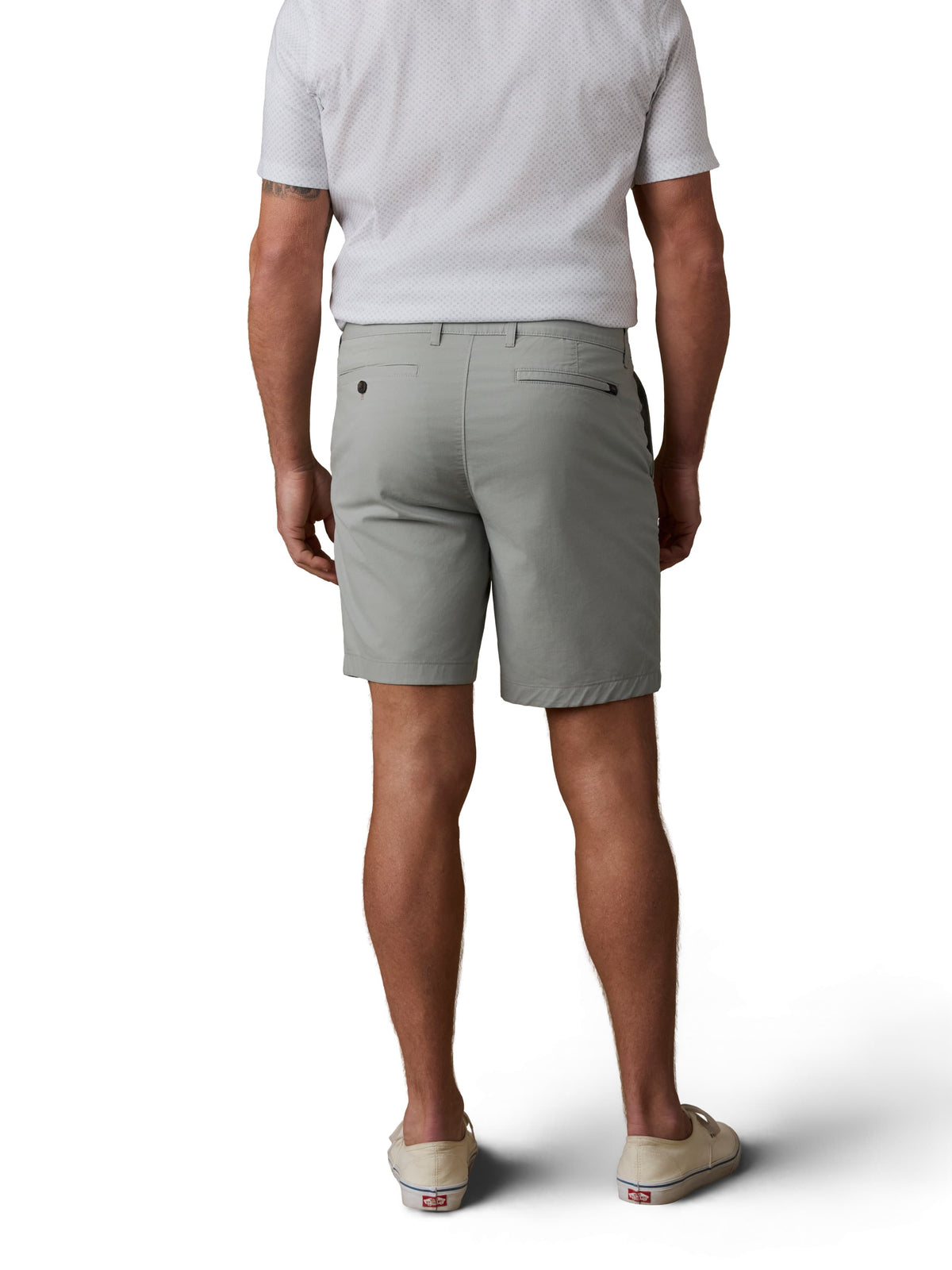 A man viewed from behind wearing a white button up shirt, sage green shorts, and sneakers, image 3 of 3