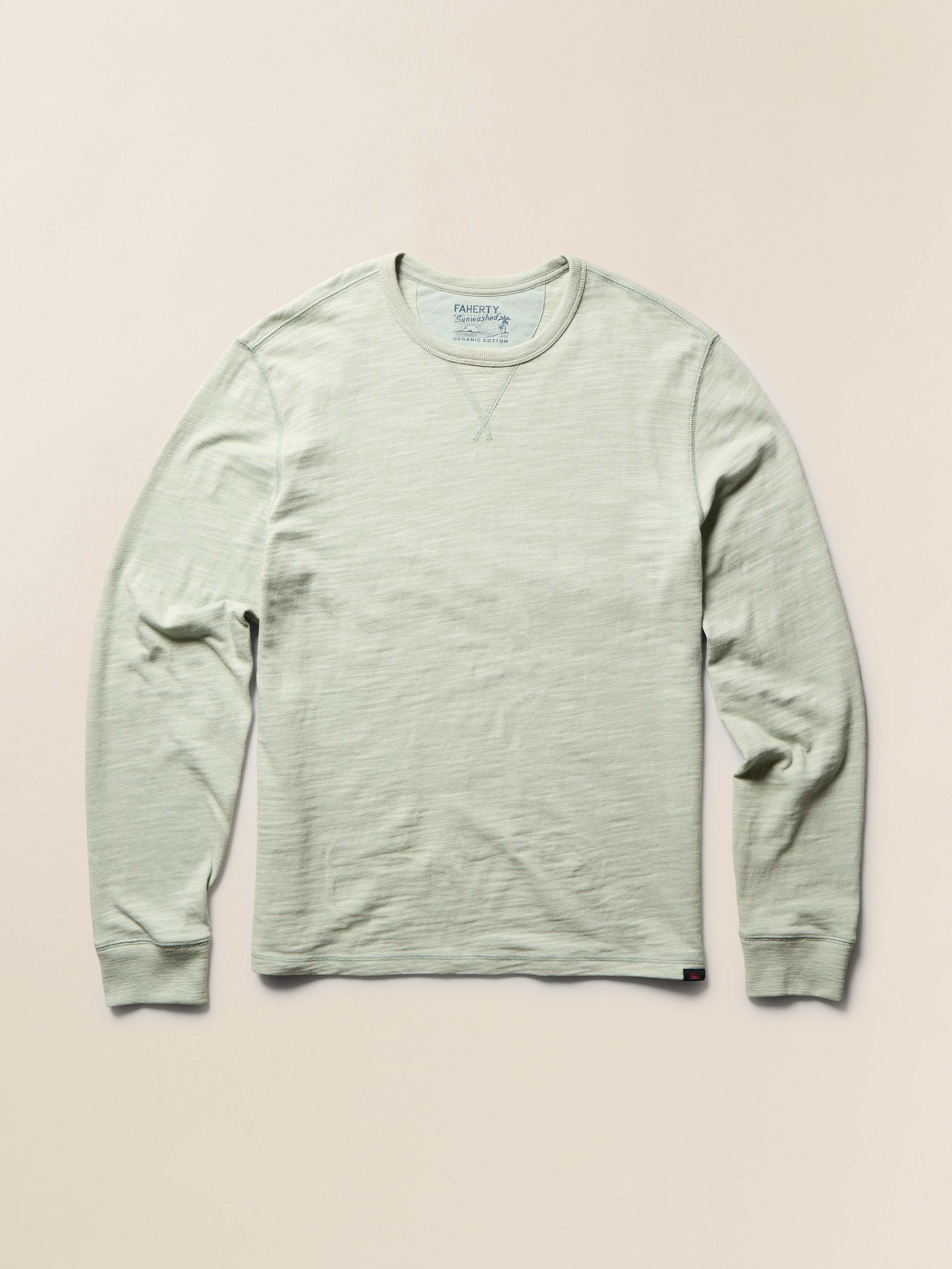 Light green long-sleeve t-shirt on a beige background